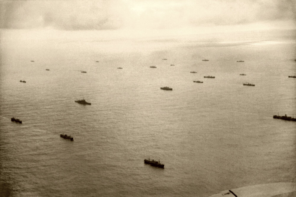 Вид с воздуха на союзный конвой в Атлантическом океане. В кадре также виден британский линкор из состава эскорта.