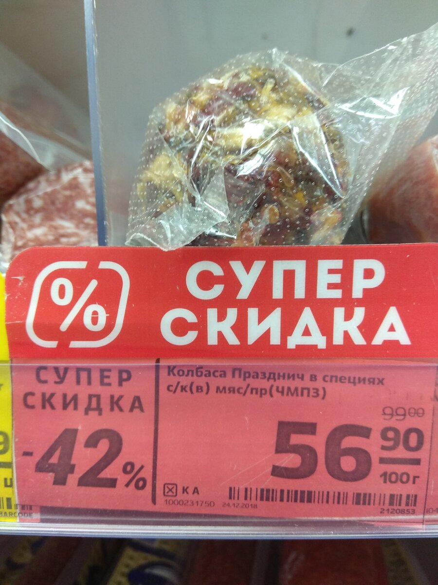 Скидка на колбасу Праздничная в специях 42 процента. Всю неделю ее можно купить за 57 рублей за 100 грамм. Прошу обратить внимание что цена стоит за 100 грамм, а не за единицу товара. Килограмм такой колбаски обойдется в 570 рублей.