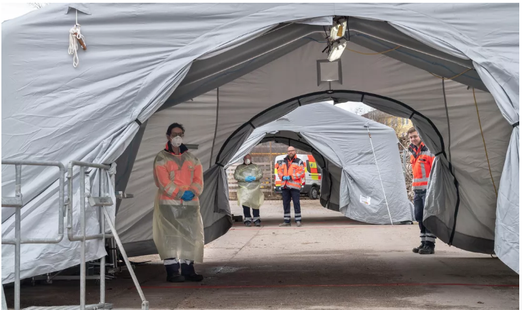 Медицинский персонал в Германии ждет на новой испытательной станции для въезда в бывшие казармы, созданной для тестирования на коронавирус. 