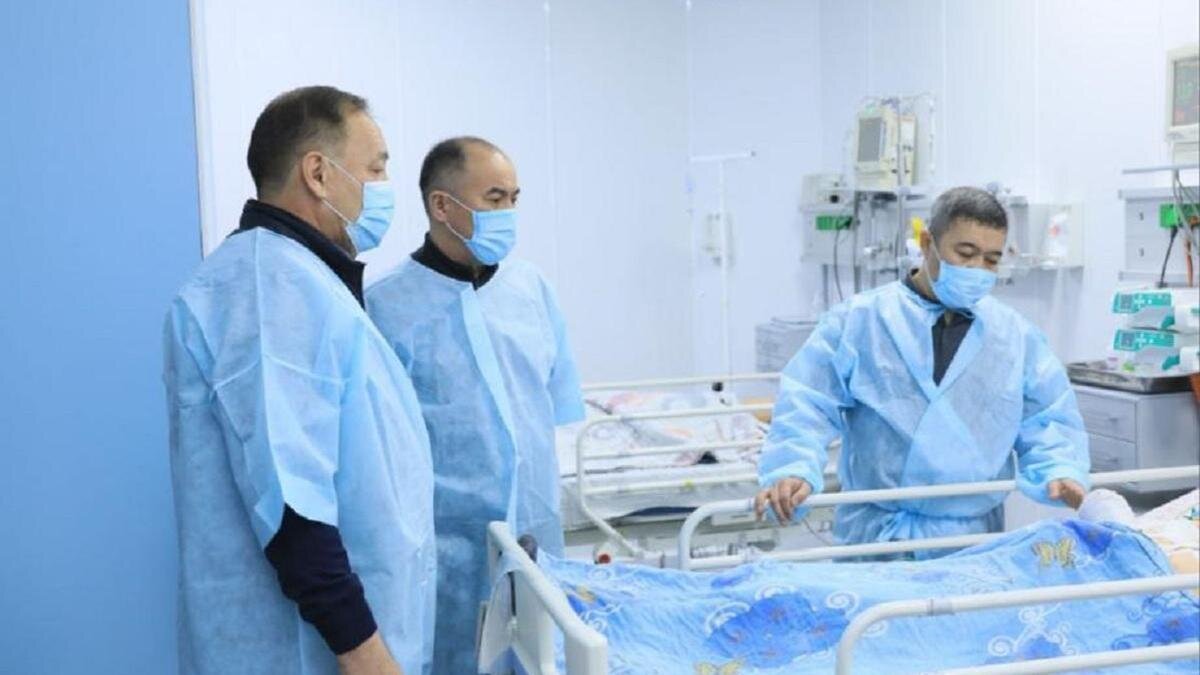    Трое мужчин в больничной палате возле детской койки:акимат Актюбинской области