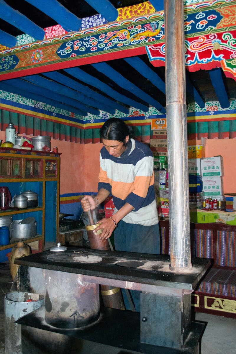 Монах изготавливает чай. Можно хорошо разглядеть, как выглядит типичная тибетская плита для приготовления пищи. Здесь она явно дорогая и в хорошем состоянии