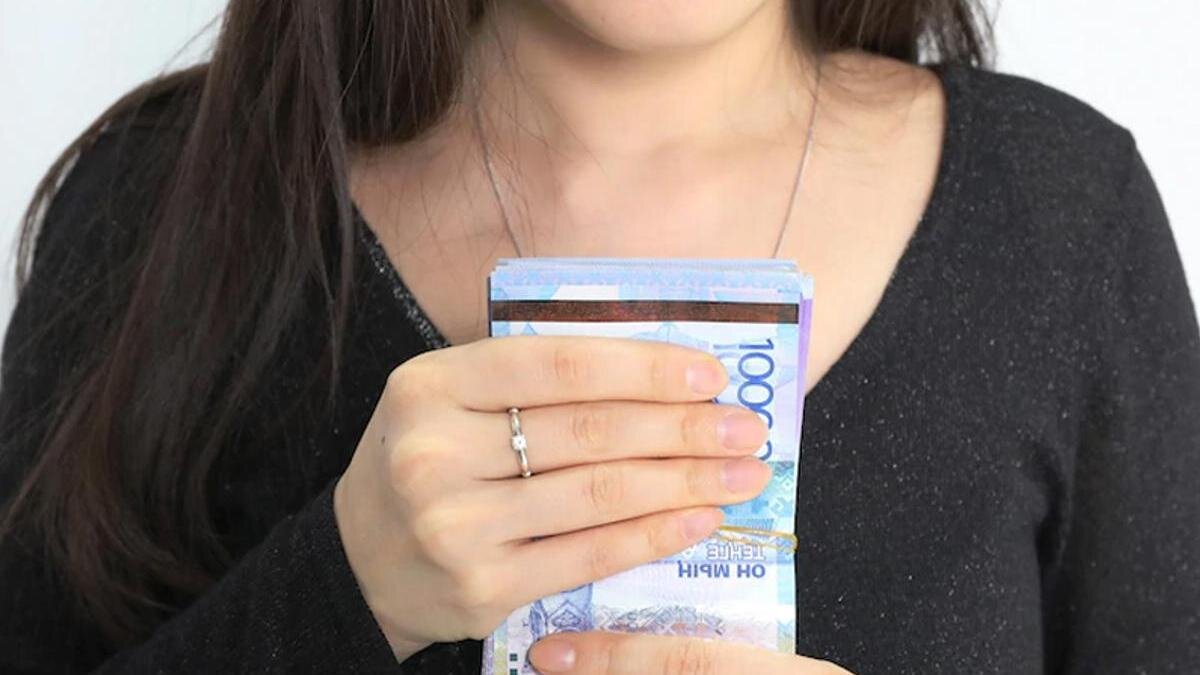   Женщина держит купюры:NUR.KZ/Петр Карандашов