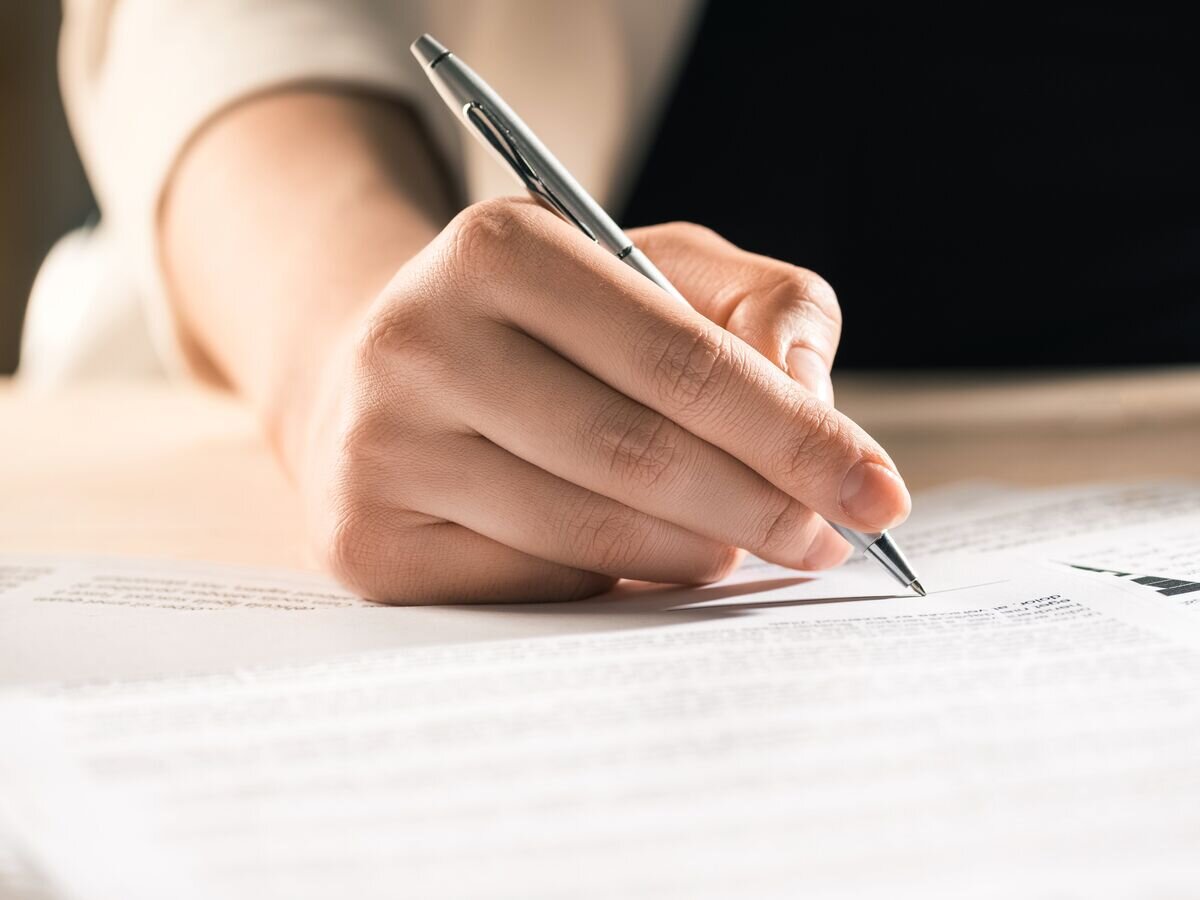    Мужчина подписывает документы© Depositphotos.com / SergPoznanskiy