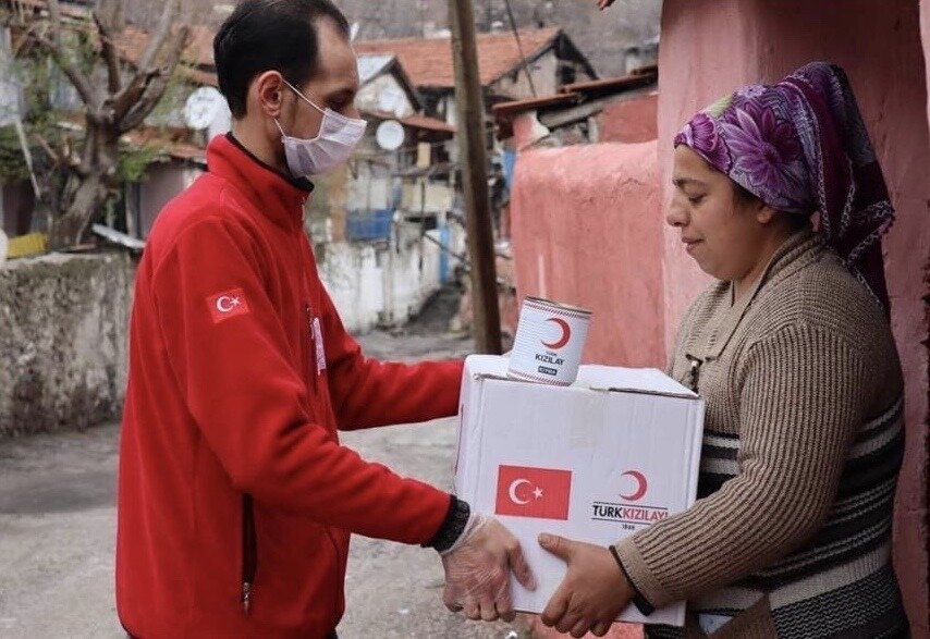 Волонтёр передаёт упакованный набор со всем необходимым