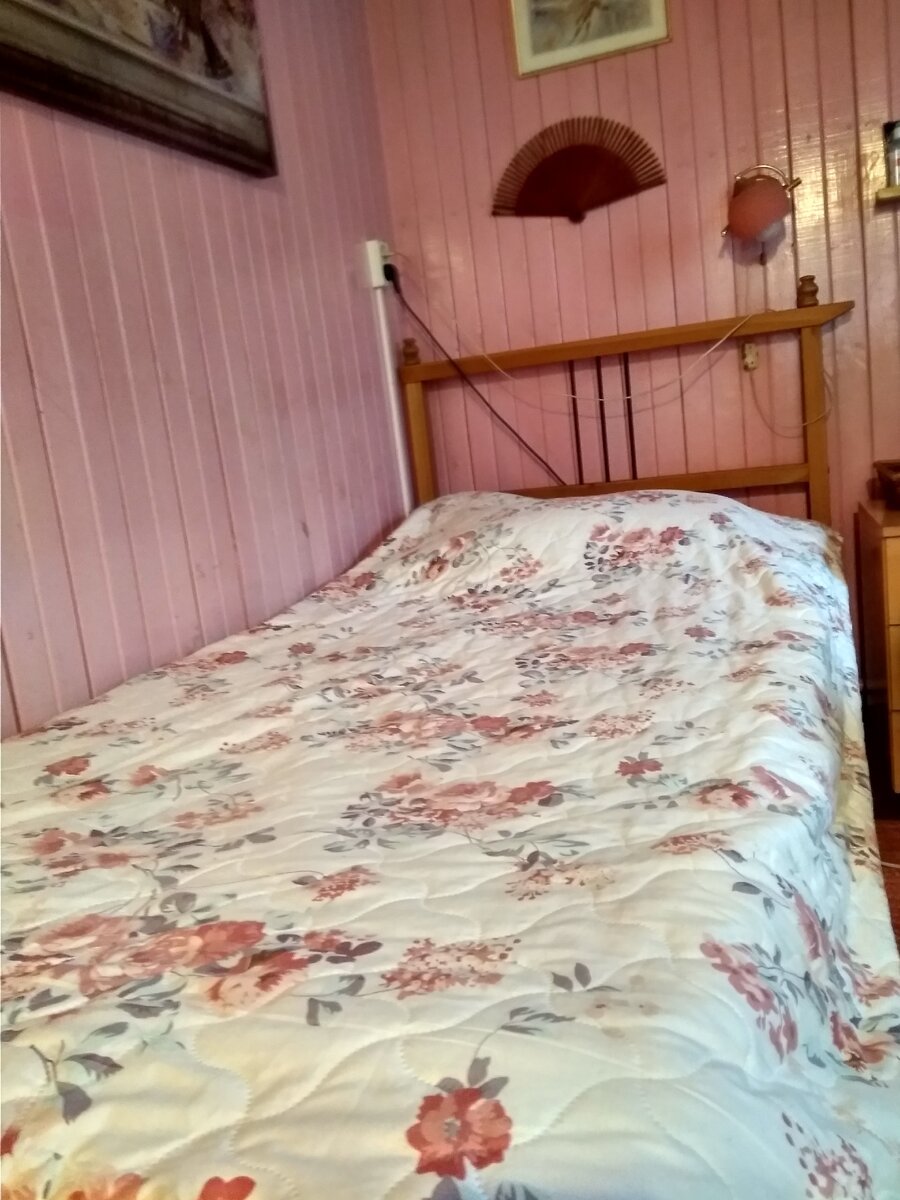 Деревянная кровать в розовой комнате.