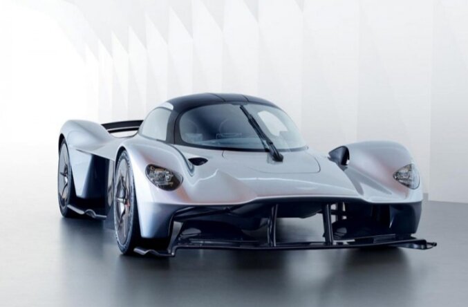 2 место – Aston Martin Valkyrie
цена – $3,5 млн.
Летом 2016-го в штаб-квартире компании Aston Martin, что в британском Гайдоне, состоялась презентация прототипа гиперкара под кодовым обозначением AM-RB 001, который впоследствии получил официальное название Valkyrie.По дизайну Валькирия напоминает скорее болид категории WEC, при этом огромная роль здесь уделена аэродинамике. Шутка ли, на максимальной скорости на гиперкар действует прижимная сила в 1 816 кг, тогда как сам автомобиль весит 1 030 килограмм.В движение гиперкар будет приводить гибридная силовая установка. Она состоит из атмосферного бензинового 6,5-литрового V12 и электродвигателя от компании Rimac. Суммарная мощность составит около 1130 лошадиных сил.