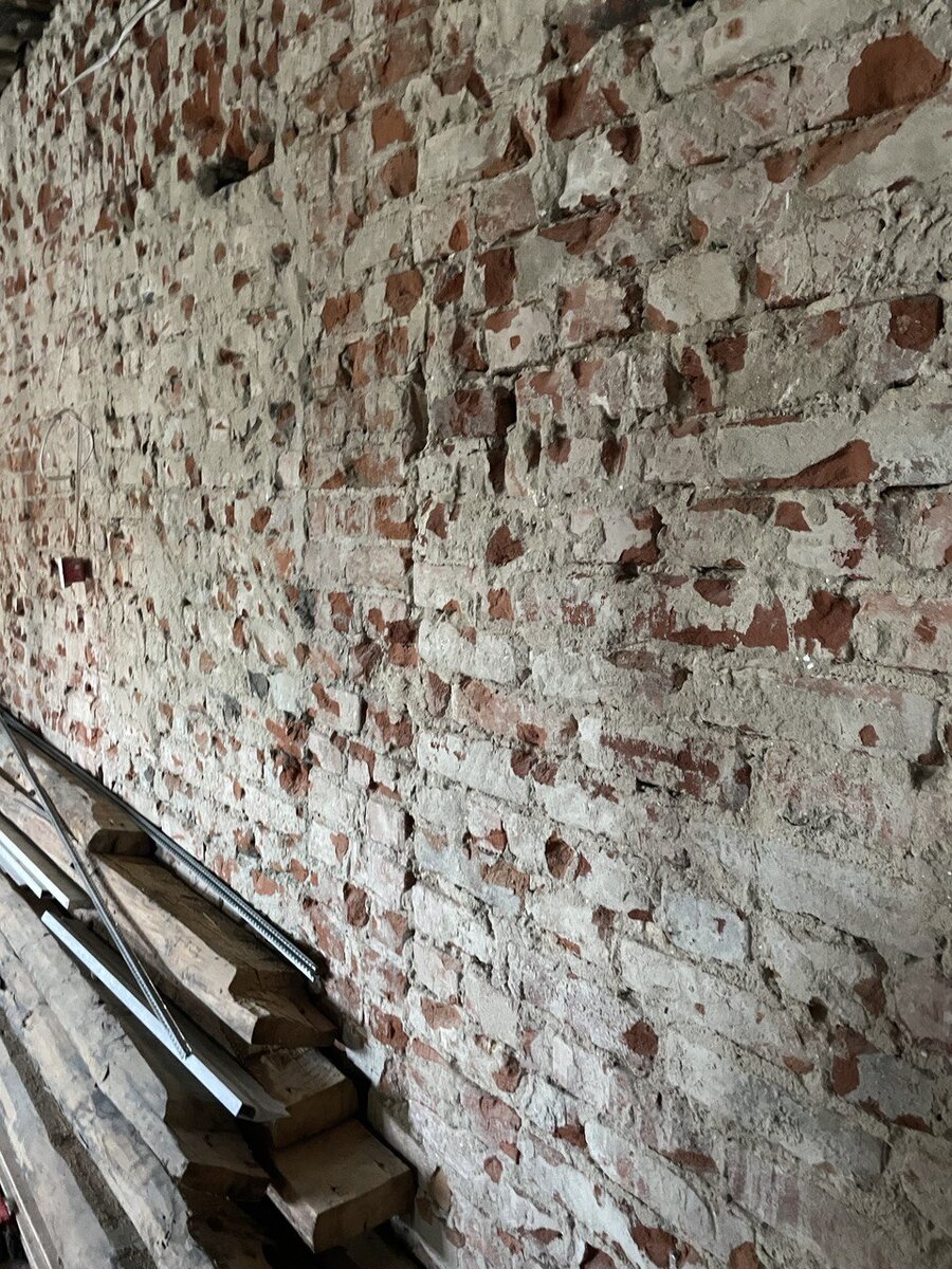 Кирпичная стена в старом фонде. Клиенты решили оштукатурить. Но можно очистить старый раствор, обработать грунтом и будет лофт.