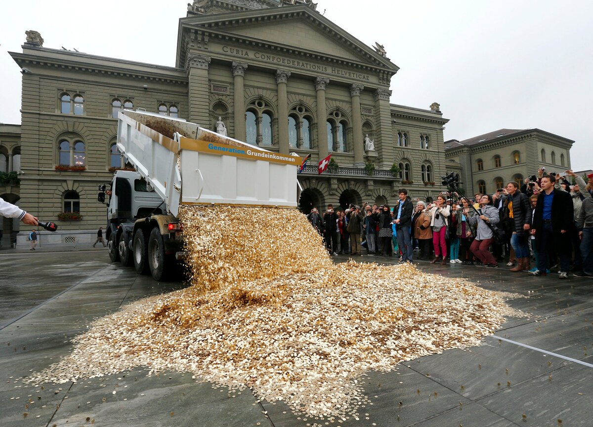 A truck dumps five cent coins in the centre of the Federal Square during a an event organised by the Committee for the initiative "CHF 2,500 monthly for everyone" (Grundeincommen) in Bern. October 4. REUTERS/Denis Balibouse