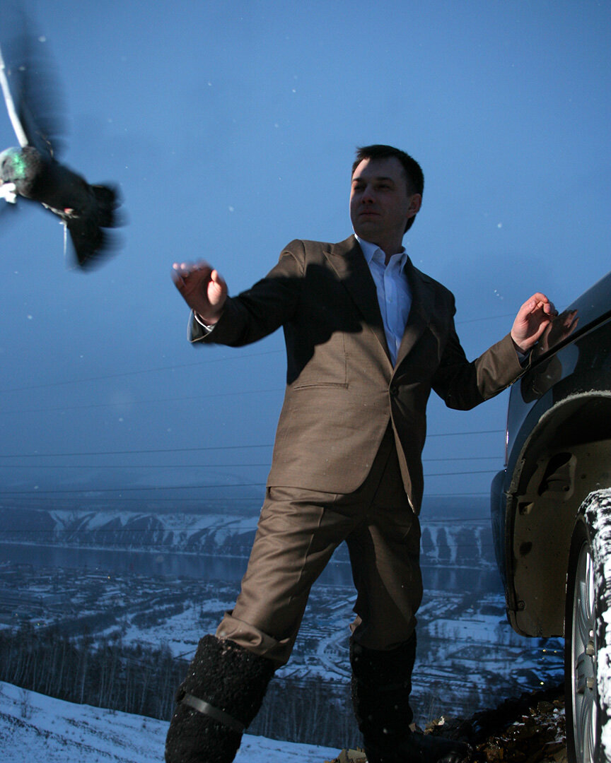    Было это в далеком 1977 году, служил я в Советской армии связистом. 
   Так была устроена система, что солдаты недоедали, причем это массовое явление. Особенно жестко было, когда периодами нам скармливали неприкосновенный (на случай ядерной войны) продовольственный запас у которого вышел срок годности, это была мерзкая еда.
   Помню как в начале 90-х когда СМИ начали публиковать реально происходящее в стране: “Зимой 1992–1993 годов в частях Тихоокеанского флота на острове Русский от голода умерли четыре матроса-новобранца. Более 250 моряков попали в госпиталь с диагнозом дистрофия”...
   Но мне как-то безболезненно удавалось адаптироваться и к дедовщине – я был комфортно коммуникабельным, и к полуголоду – ловил голубей, и к глупой службе – бегал в самоволки в библиотеку и много читал на дежурстве.
   Понятно что в такой ситуации голуби это подарок судьбы. А в соседней части солдаты охотились на бездомных собак. Спрячут во время стрельб пару патронов, а потом на дежурстве с вышки караулят случайных собак.
    Почему-то никто не мог так ловить голубей как я, хотя технология простая – движение руки должно быть на опережение взлетающего голубя и конечно моя спортивная подготовка (дзюдо и бокс) имела значение.
    Каждый солдат старался попасть со мной на дежурство, ночью мы варили голубя в электрочайнике и ели.
   Первый раз я попробовал голубя в детстве когда жил на Украине, там это деликатес, тогда мой старший брат и научил меня ловить. По вкусу птица и птица, в голод особенно вкусно. Чистота мяса – думаю, сейчас курица вреднее будет любого голубя, все знают чем кормят кур.

НА ФОТО бывший директор автосалона Ленд Ровер, мне заказали его портрет для глянцевого журнала. По замыслу он должен был запускать голубя как символ мира, ведь этот директор раньше воевал в нескольких горячих точках. Но у него получалось бросать голубя как гранату, поэтому я предусмотрительно наловил несколько штук и засунул в наволочку, как раньше делал в армии. Только с последним голубем у него получилось по человечьи, но птица дала тень на лицо и это оказалось символично.