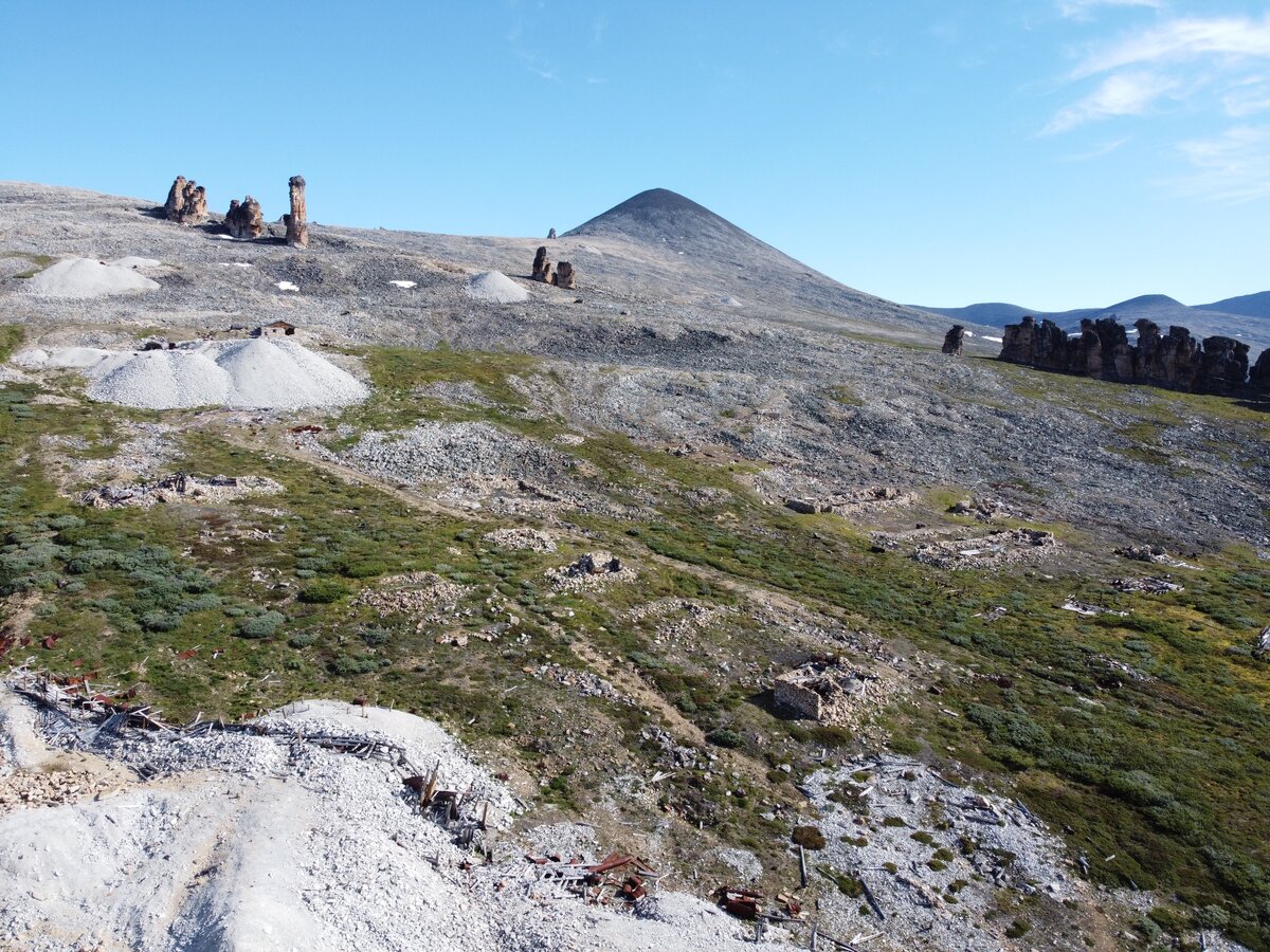 Отвалы штолен и руины строений бывшего лагерного поселка «62 км». На заднем плане — гранитные кекуры — характерная черта рельефа Западной Чукотки. Фото Ф.А. Романенко, 2020