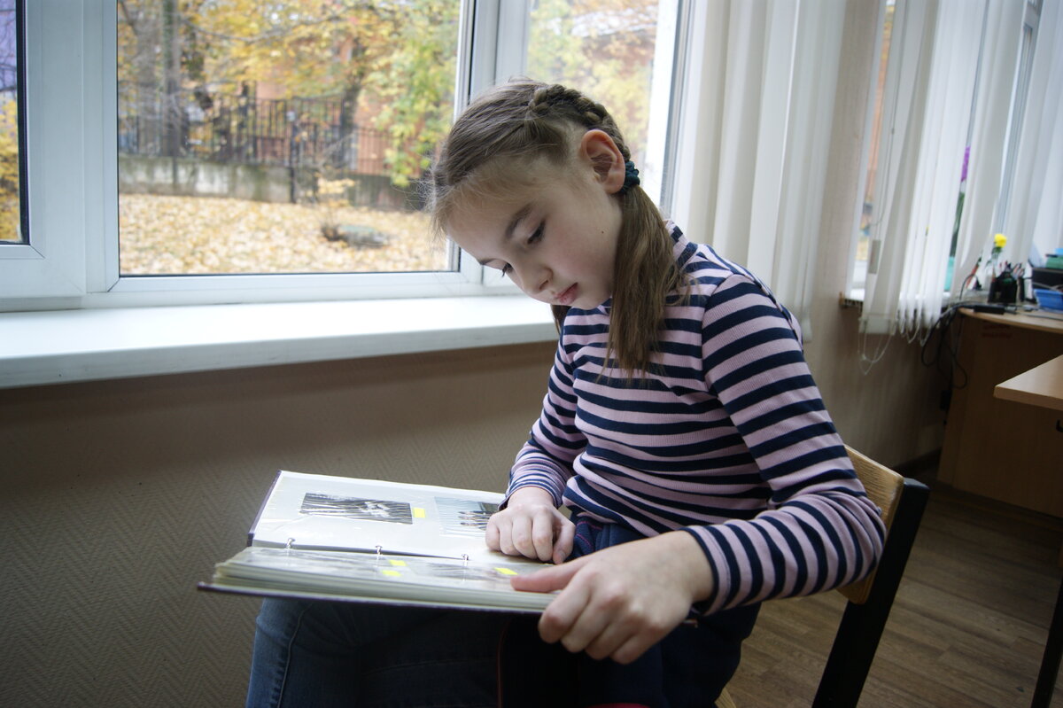Настя изучает семейный фотоальбом. Фото: Студенников Константин 
