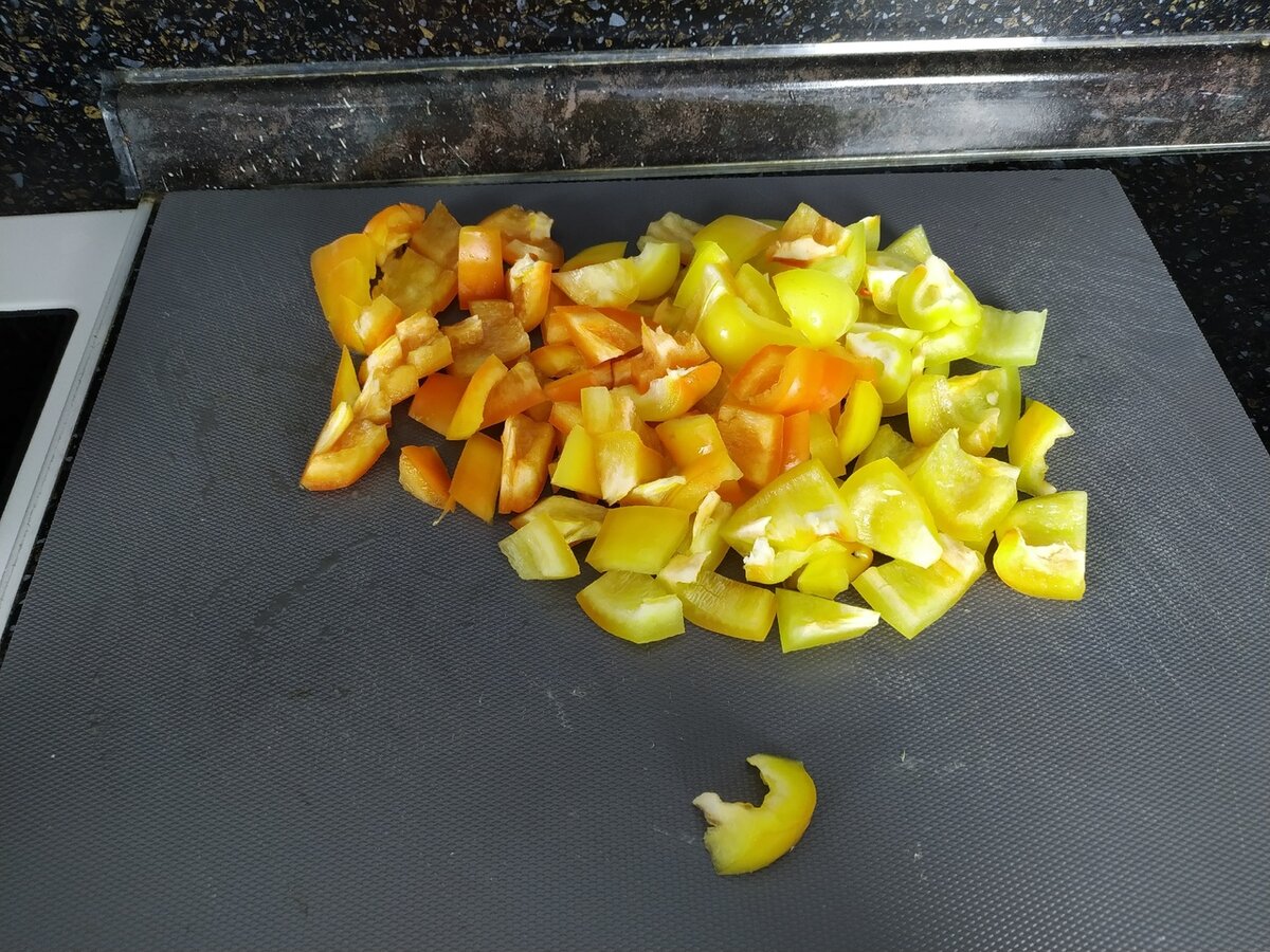 Болгарский перец очистить от семян и нарезать крупными кубиками. В глубокой сковороде разогреть оливковое масло, отправить туда болгарский перец и обжаривать на сильном огне в течение 3 мину, перемешивая.