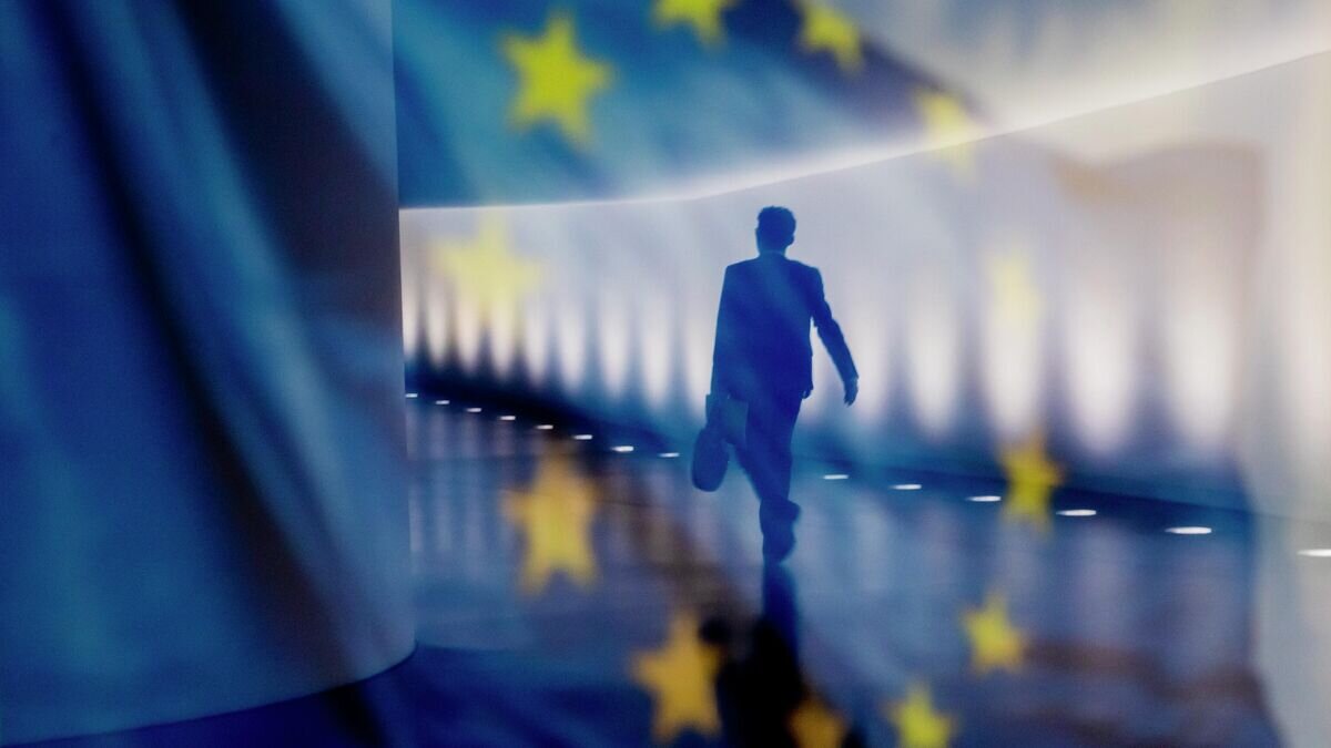    Отражение мужчины на фоне флага ЕС© AP Photo / DPA/ Christoph Soeder