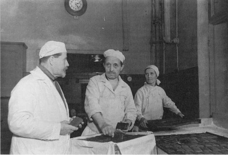 Подпись под фото "12.12.1941 года 2-я кондитерская фабрика. Начальник цеха А.Н.Павлов, мастер-кондитер С.А.Краснобаев и подручная Е.Ф.Захарова за осмотром готовых батонов"