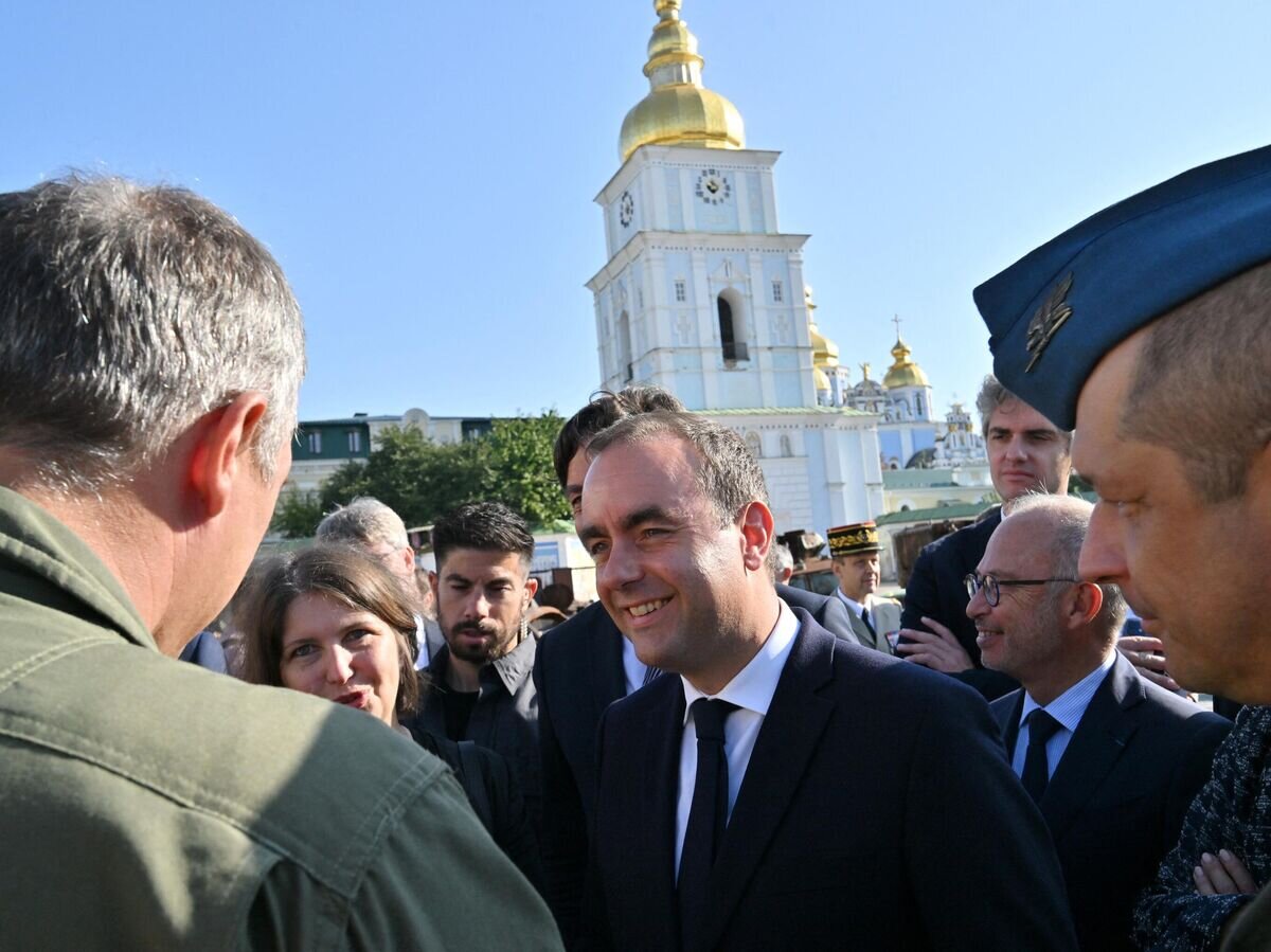    Министр армии Франции Себастьян Лекорню (в центре) обращается с прессой на фоне Михайловского Златоверхого собора в Киеве© SERGEI SUPINSKY