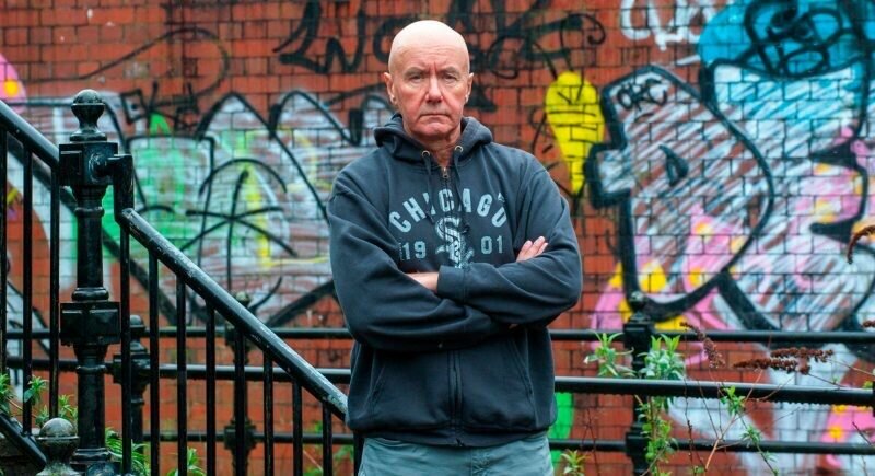 «Клей», «Дерьмо», «Экстази», «На игле» – нет, это не просто набор названий, это названия книг, ставших культовыми. Поговаривают, что их должен прочитать любой уважающий себя человек независимо от его пола и политических взглядов. Содержание
Ранняя смерть отца
Во все тяжкие
Взялся за голову
Грязь плюс философия
Мастер пера
Пенсия
Автором этих и других произведений является Ирвин Уэлш. Он до сих пор остаётся на слуху, хотя уже не занимается писательской деятельностью. Его творчество любят от мала до велика. За что и почему? Сейчас мы вам и расскажем.

Ранняя смерть отца
Родился будущий автор культовых произведений современности 27 сентября 1958 года в провинциальном портовом городе под названием Лит, который расположен неподалеку от столицы Шотландии Эдинбурга.
В некоторых источниках пишут, что истинным годом рождения писателя является 1951 год. Правды мы видимо никогда не узнаем.
Когда Ирвину исполнилось 4 года, его семья переехала в Эдинбург. Мама устроилась работать в местный ресторан официанткой, а папа трудился в порту до тех пор, пока у него не начались проблемы с легкими.
«Я вырос Эдинбурге, где все были великими рассказчиками, но никто не умел писать. У каждого в пабе была своя великая история и каждый умел ее стройно рассказывать. Истории здесь можно было услышать даже на рейвах и в клубах», – говорил Ирвин.
Когда герою нашего материала исполнилось 25 лет, его папы не стало. Весь груз семейных хлопот взвалился на маму. Разумеется, с большими тратами пришлось завязать, тем более их семья никогда не относилась к высшим слоям общества. Поэтому юному Ирвину часто приходилось оставаться без подарков на Рождество. Ведь весь семейный бюджет уходил на покупку одежды и еды.
Ранняя потеря отца только закалила Уэлша, он уже в 16 лет устроился на свою первую работу.
«Я зарабатывал 17 фунтов в неделю, помогая телевизионному мастеру. В 1976-м это были неплохие деньги, но работа потеряла привлекательность после того, как какой-то с**ный телевизор долбанул меня током», – вспоминает писатель

Во все тяжкие
Когда Ирвину исполнилось 20 лет, он решил отправиться покорять Великобританию. На Туманном Альбионе юноша всячески пробовал раскрыть свой потенциал.
Сначала он играл на гитаре в различных панк-коллективах, параллельно с этим он подрабатывал укладчиком плит и даже поваром. По итогу Уэлш плотно подсел на героин и стал часто проводить время с друзьями из плохих компаний.
«Наркотики стали для меня проблемой летом 1982-го. В один момент они перестали быть развлечением и стали жизненной необходимостью. Так начался период воровства и лжи. В один момент я понял, что не контролирую свою жизнь», – говорил Уэлш.
Также стоит отметить, что Ирвин был единственным из своей компании, кто выжил после эпидемии ВИЧ.
Дима Корунов
Этот этап его жизни нашел отражение в написанных им романах, таких как «На игле», «Три теории любви и Химии» и «Тупая Езда».
Всю жизнь писателя в Северном Лондоне можно назвать трудной. Ему не раз приходилось нарушать общественный порядок, из-за чего он имел проблемы с законом. Но Ирвин вовремя понял, что становиться отбросом общества нельзя, ведь у него уже были задатки к написанию различных литературных произведений, нужно было лишь направить свои силы в правильное русло.
«Написать книгу – это способ словить кайф, какого не даст ни один наркотик. Когда ты пишешь книгу, правил вообще нет».
Взялся за голову
В начале 80-х годов Ирвин в прямом смысле слова решил взяться за ум и стал работать риэлтором. Как раз в те годы в Великобритании начался строительный бум.
Но перед этим с Уэлшем произошел несчастный случай. Ирвин попал в аварию и получил за это компенсацию в размере двух тысяч фунтов. Эти деньги писатель сразу вложил в недвижимость.
После успешной работы в Лондоне Ирвин возвращается в родную Шотландию, где получает образование по специальности «Информатика» и плотно подсаживается уже не на наркотики, а на писательское ремесло.
«Я стал писателем, потому что всегда хотел быть представителем людей, которых вижу вокруг, но о которых никто не пишет».
Грязь плюс философия
В начале 90-х Ирвин из-за скучных трудовых будней в офисах (Уэлш по приезду в Шотландию устроился работать инструктором в жилищный отдел) начинает заниматься написанием первых книг.
Дебютный автобиографический роман под названием «На игле», вышедший в свет в 1993 году, сходу становится бестселлером. В этом творении под большим слоем “грязи” можно проследить (если вы конечно внимательно читали книгу) философские мысли. Именно поэтому «На игле» получил известность.
Дима Корунов
«Я не думал, что «На игле» когда-либо опубликуют. Это был крайне самолюбивый поступок – я писал книгу для самого себя».
Примечателен тот факт, что данное произведение было написано с чрезмерным использованием молодежного сленга и нецензурной брани. Поэтому людям, привыкшим к классике а-ля Чехов и Толстой, очень трудно дастся этот роман.
В 1995 году режиссер Дэнни Бойл, вдохновившись романом Ирвина, выпустил на большие экраны одноименную драму.
«Пусть сами решают, как и что снимать. Нужен я им для консультаций – всегда пожалуйста, буду рад помочь. Не нужен – постою в сторонке», – говорил Уэлш.
Мастер пера
После всемирного успеха «На игле» Ирвин продолжает писать произведения в похожей стилистике. В 2002 году в свет выходит сиквел под названием «Порно». Ближе к нашим дням, в 2012 году, презентуется одно из крайних творений Уэлша «Мальчики на дозе», которое тоже получает свою порцию внимания, в том числе далеко за пределами Англии.
Роман героя «Кошмары аиста Марабу», который рассказывает о маргинале, находящемся в коме, был издан более пяти раз и переводился на разные языки.
В 1998 году писатель открывает читателям суровые реалии бытия дерзким произведением под названием «Дерьмо». В нём главная роль отведена продажному копу Брюсу Робертсону. Шесть лет назад по мотивам этой книги выходит фильм «Грязь» с Джеймсом Макэвоем в главной роли.

В 2001 году Ирвин выпускает роман под названием «Клей», который был написан в жанре контркультуры, в нём вы тоже можете отследить молодежные диалекты и много черного юмора. Это четырехполосный роман воспитания, доподлинный эпос гопников и футбольных фанатов, трогательная история о любви и дружбе.

В 2014 году писатель выпускает неоднозначный роман «Сексуальная жизнь сиамских близнецов». На журналистов издания The Guardian этим произведением Уэлш производит впечатление ненадежного рассказчика, не полностью раскрывающего главную мысль.
«Идеи сегодня слишком переоценены. Как писателя меня раздражают люди, которые приходят ко мне и говорят: «Я не писатель, но у меня есть охренительная идея для книги». Эти люди даже не подозревают, что у меня целый сарай идей и что придумать нечто выдающееся вовсе не проблема. Проблема – это усадить себя за стол и реализовать то, что ты придумал».
Позже писатель стал писать для книги заметки, которые вызывали у людей различного рода дискуссии.
Пенсия
Сейчас 61-летний Ирвин проживает в Америке вместе со своей женой Элизабет. Детей у них нет, поэтому Уэлш успевает заниматься благотворительностью и сниматься в кино. Например, в последний раз он мелькал на экранах фильма «Т2: Трейнспоттинг» («На игле 2»), режиссером которого выступил его давний друг Дэнни Бойл.
«Есть люди, которые думают, что хороший читатель может стать хорошим писателем. Херня. Чтобы быть писателем, нужно прожить безумную жизнь. Иначе ты останешься собирателем чужих мнений и монтажером чужого опыта. Мне повезло. Я написал нечто, ставшее феноменом, и не стал пленником этого феномена».