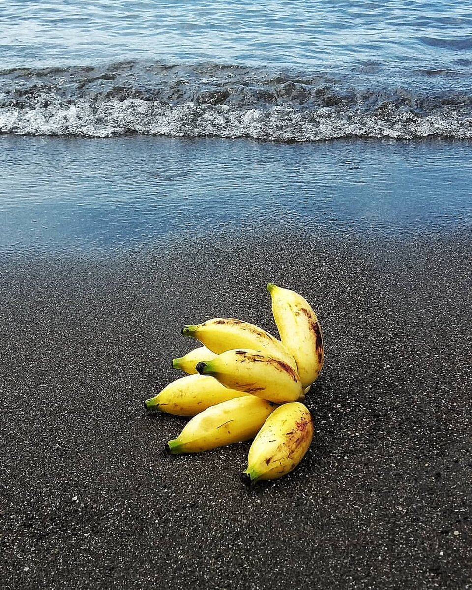 Желтые бананы на черном песке