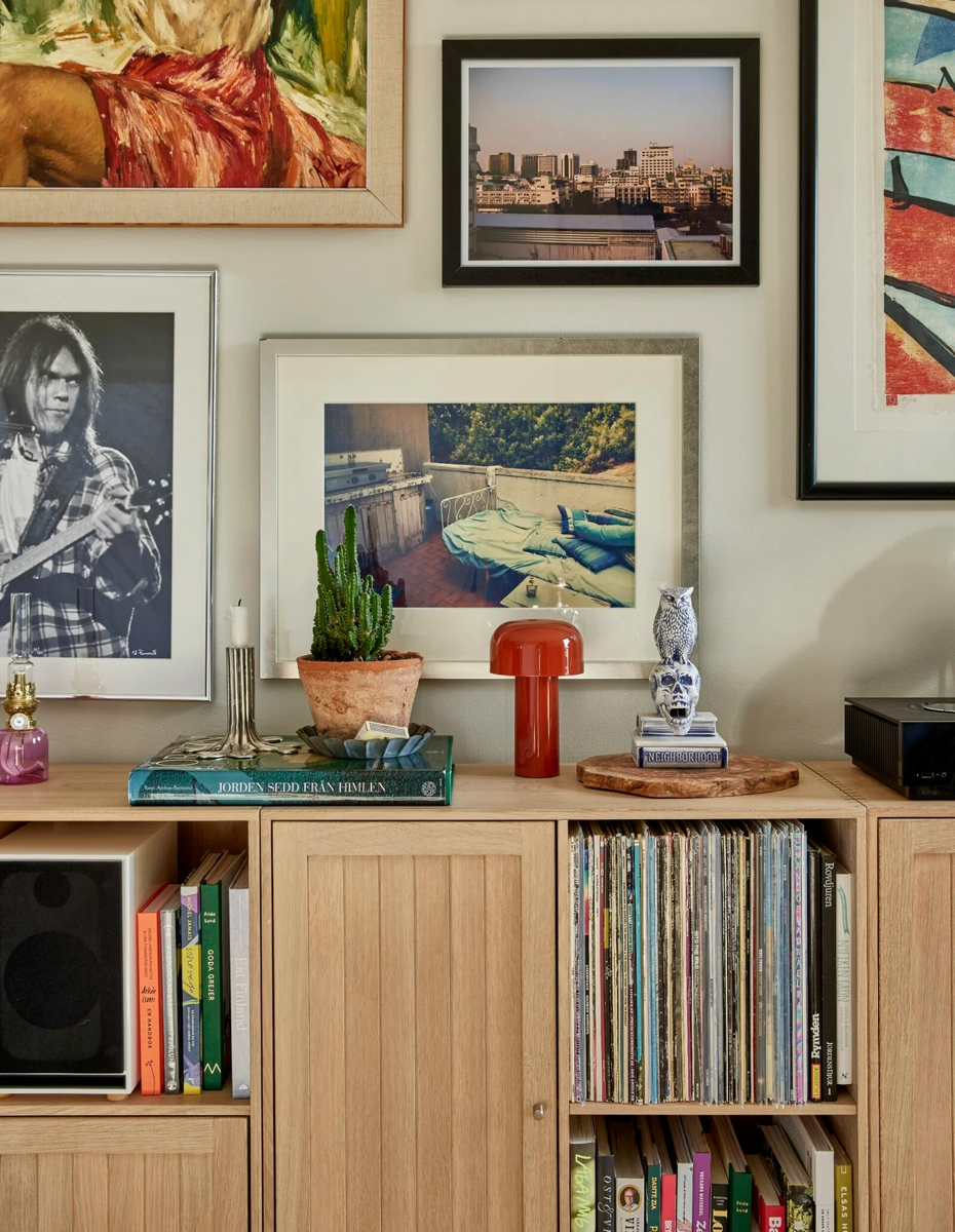 На стене — коллекция картин и памятных фотографий. Интересно, что предметы искусства сочетаются с обычными фотоснимками