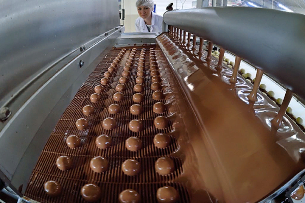 Новосибирская шоколадная фабрика конвейер. Производство шоколада конвейер. Формовка шоколада. Конвейер на конфетной фабрике.