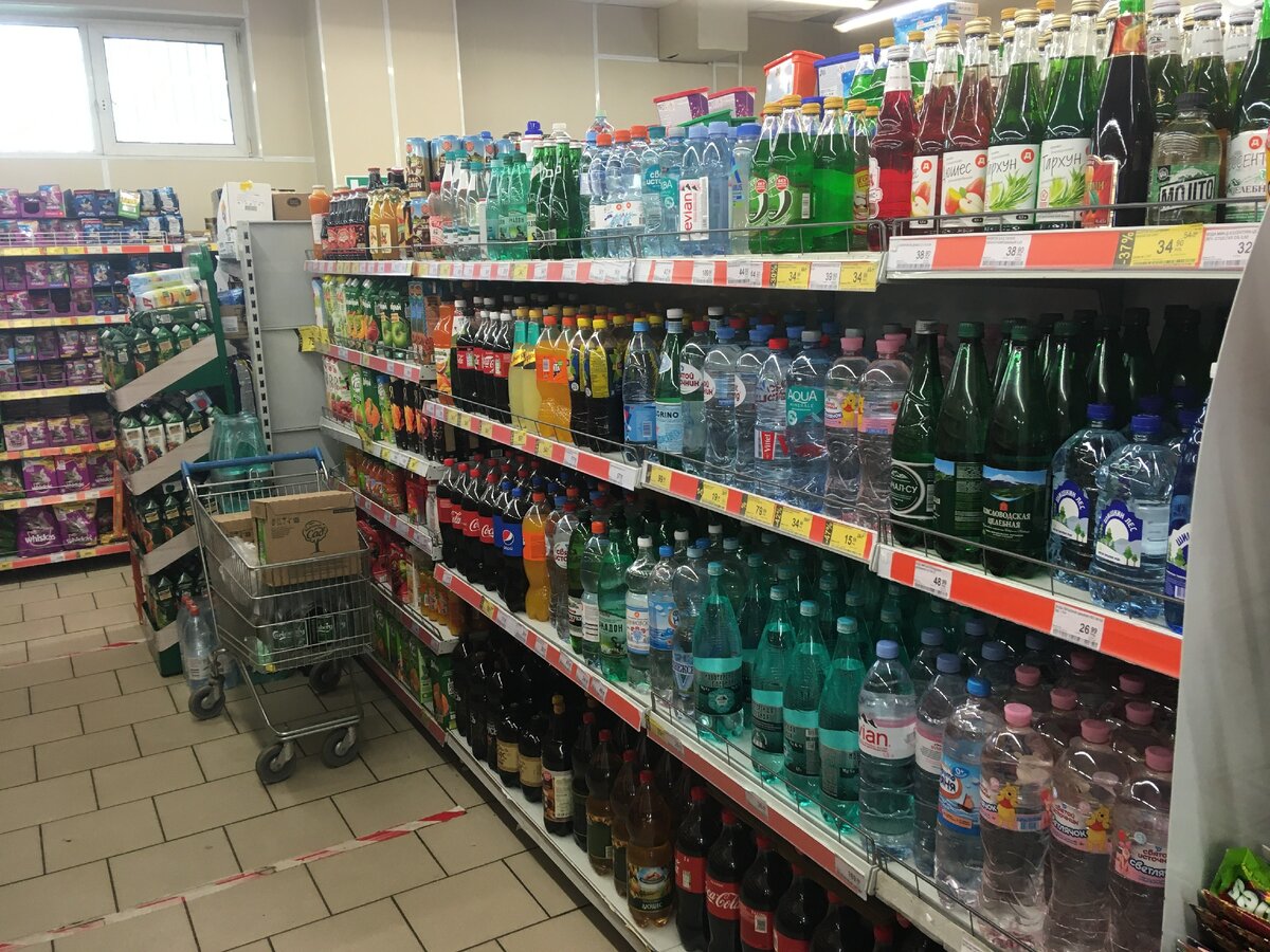 Полка с соками, газированными напитками и водой. Мерчандайзер бросил тележку в зале и ушел.