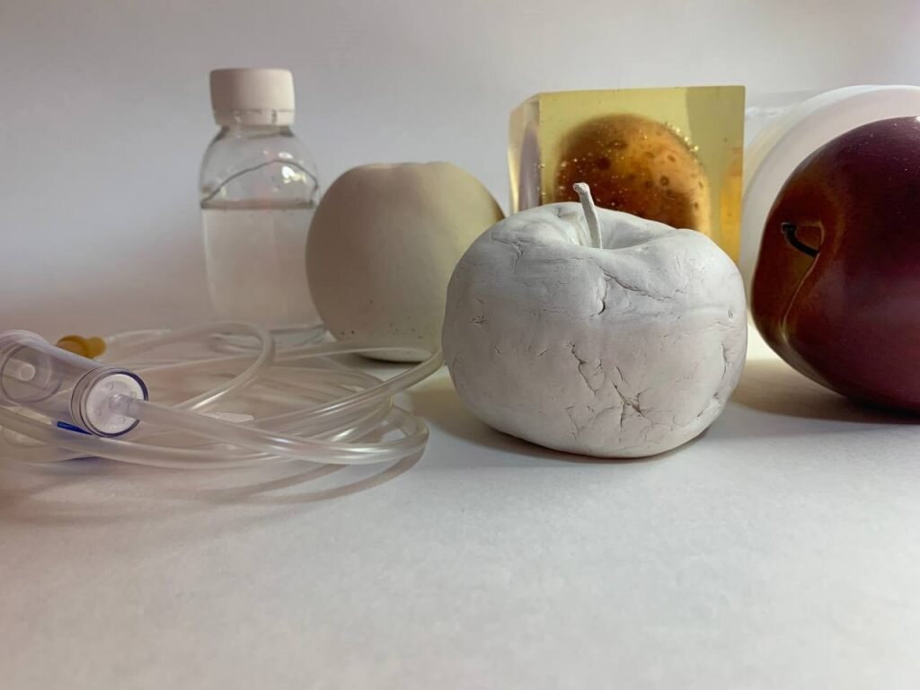 Дарья Федорова «Райское яблоко», 2021. Инсталляция. Гипс, глина, эпоксидная смола, глицерин, штатив для капельницы, синильная кислота, продукты органического распада, ароматизатор, мысленная проекция яблока, пластиковая копия © Объединение «Выставочные залы Москвы»