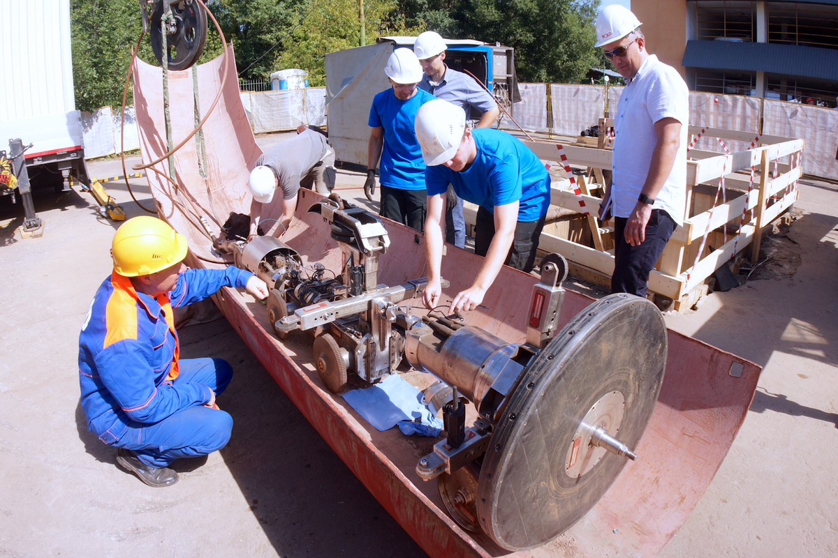 Сотрудники теплосетей столицы проверяют датчики робота и готовят его к спуску в трубу по специальному желобу. Фото Аркадия Колыбалова, «РГ»