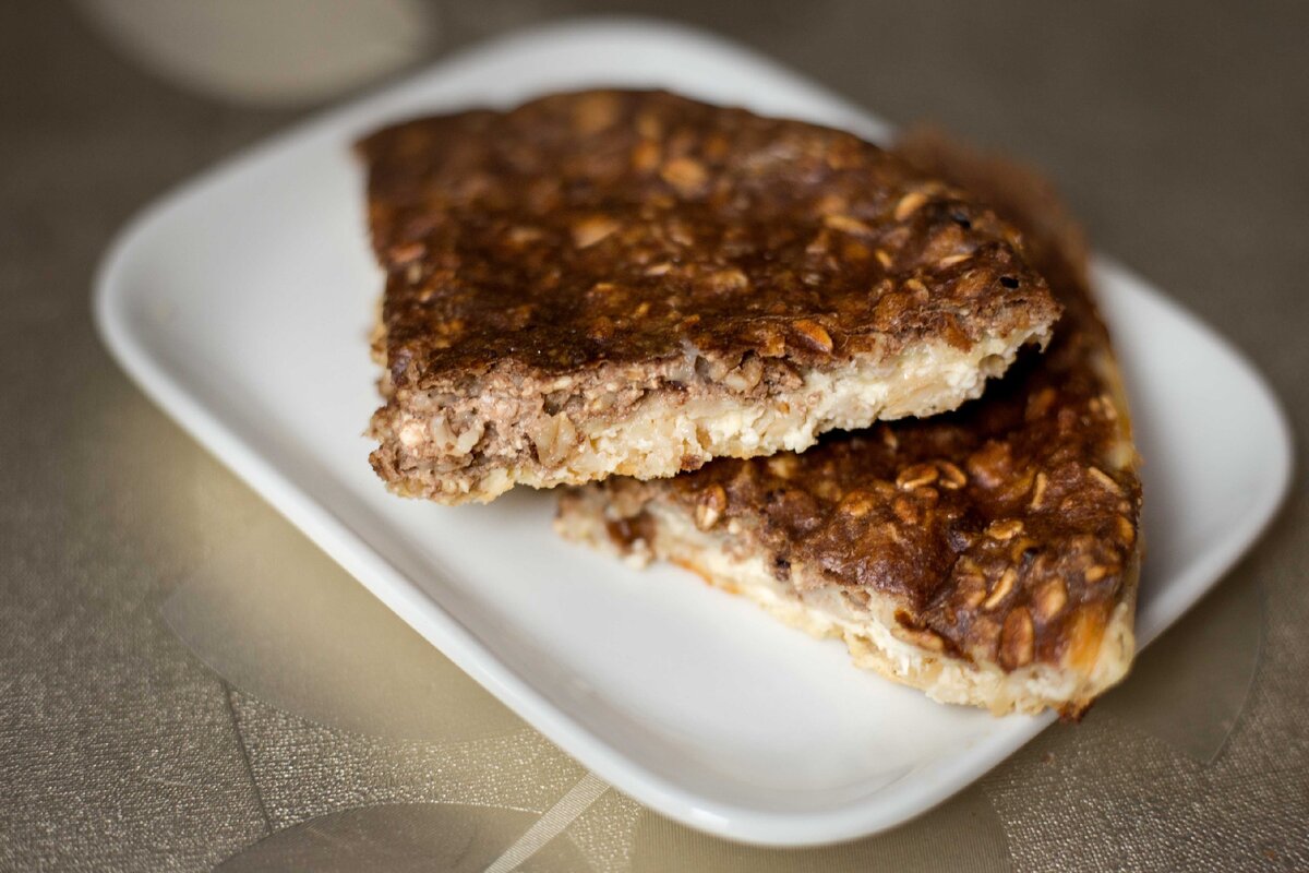 Овсяные хлопья 50 гр. (175 ккал Б 6 Ж 3 У 31), творог 2 % 180 гр. (185 ккал Б 32,4 Ж 3,6 У 5,94), яйцо 1 шт. ( 80 ккал Б 6,3 Ж 5,4 У 0,35), кефир 50 мл. ( 20 ккал Б 1,4 Ж 0,5 У 2), кэроб   5 гр. ( 11,1 ккал Б 0,23 Ж 0,035 У 2,45), банан 75 гр. ( 71,25 ккал Б 1,12 Ж 0,15 У 16,35), подсластитель по вкусу. Овсяные хлопья смешала с кефиром, оставила набухать на 15 минут. Творог смешала с яйцом и подсластителем, добавила овсянку с кефиром, половину теста выложила в силиконовую форму, у меня 15 см. Банан покрошила кольцами и выложила на первый слой теста. Во вторую половину теста добавила кэроб и выложила сверху на бананы. Выпекала 45 минут при температуре 160 градусов. 