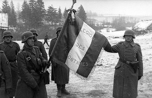 Легион французских добровольцев против большевизма (фр. Légion des Volontaires Français contre le Bolchévisme — пехотный полк, сформированный во Франции и принявший участие в боевых действиях на Восточном фронте Второй мировой войны на стороне Германии. На фото добровольцы со знаменем легиона. СССР, ноябрь 1941. 10 августа 1944 года легион был передан в формирующуюся 33-ю дивизию СС «Шарлемань».