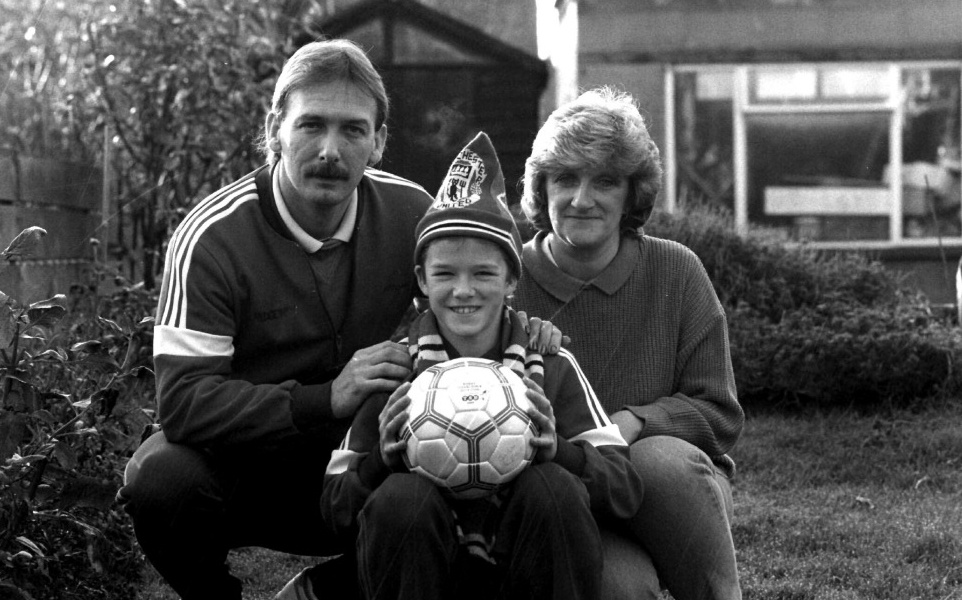 Бекхэм с родителями. На будущем игроке МЮ атрибутика любимого клуба.