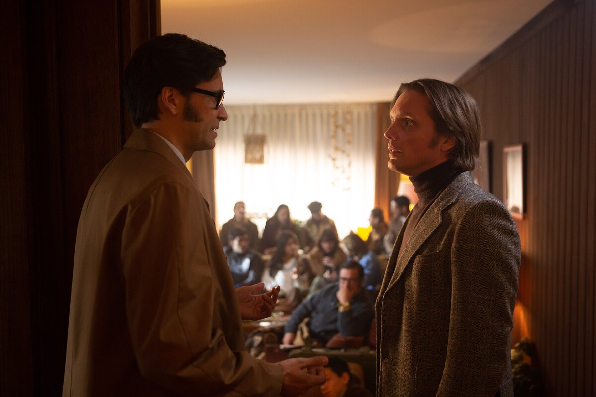 Посол Финляндии Тапани Бразерус справа, беседует в своём доме с коллегой, на фоне беженцев.