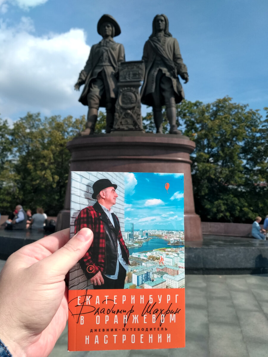 Книга на фоне памятника отца основателям Екатеринбурга, называемых в народе Бивис и Батхед. Фото сделано в день 300-летия Екатеринбурга, 19 августа 2023 г.