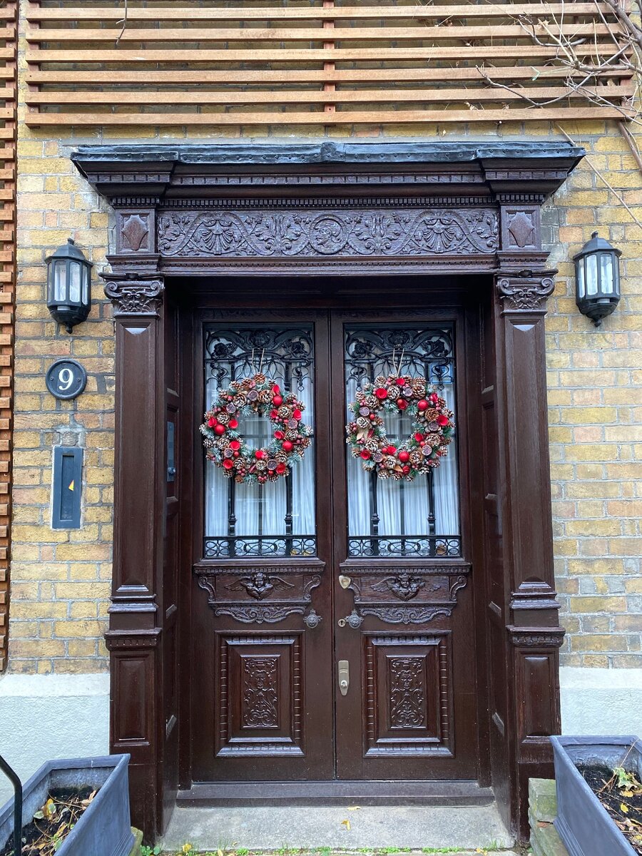 Практически каждая дверь украшена рождественским венком