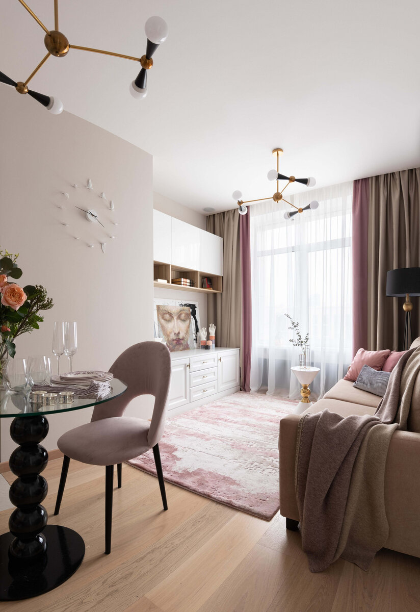 Добавляют разнообразия белый кофейный столик интересной формы и графичный торшер черного цвета.