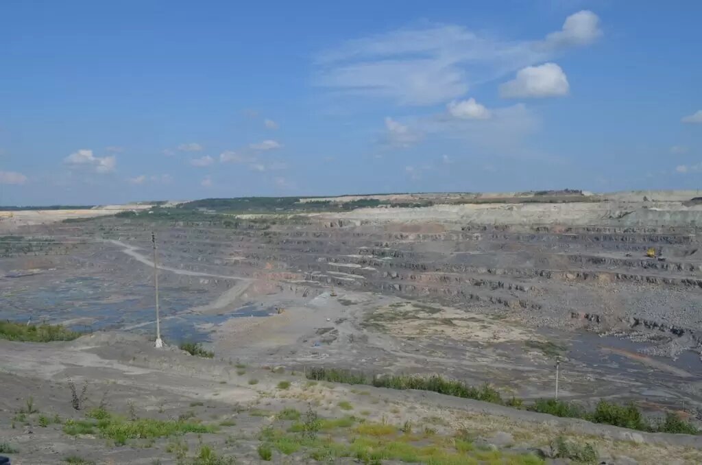 По серпантину движутся малюсенькие, размером со спичечный коробок БелАЗы