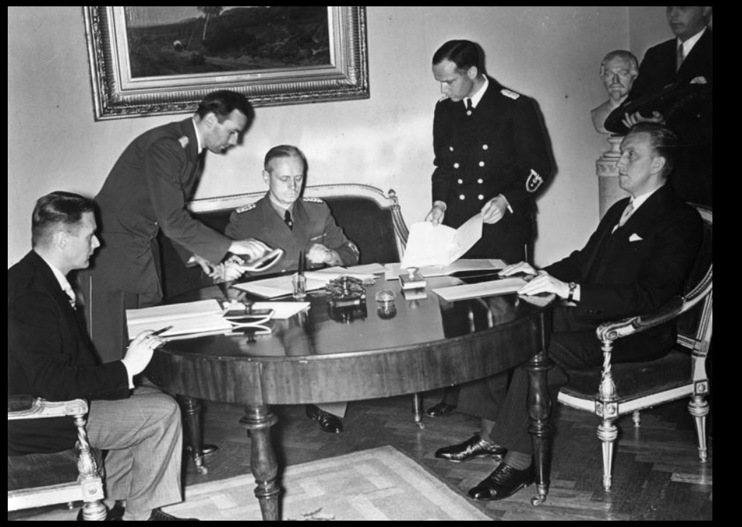 Подписание германо-эстонского и германо-латвийского договоров о ненападении. Сидят (слева направо): В. Мунтерс, И. фон Риббентроп, К. Сельтер. 