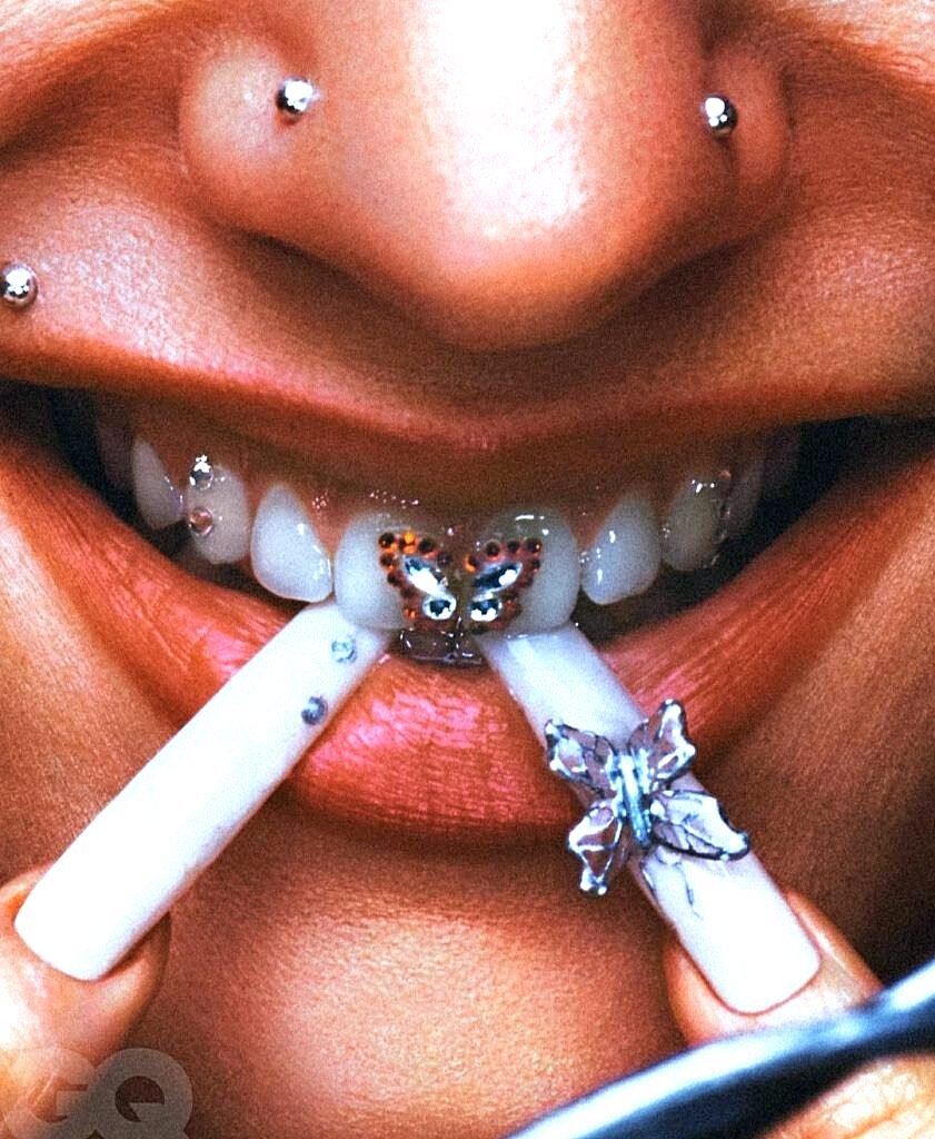 На фотографии с журнала GQ, Розалия носила украшение в виде бабочки на зубах. Помимо этого, бабочка Монарх присутствовала и на ногтях певицы.