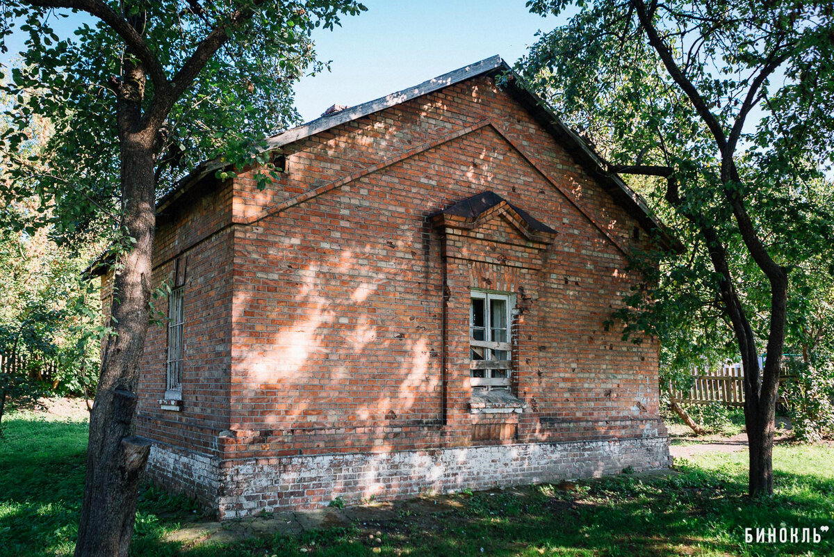 Раз уж мы выбрали маршрут в обход торжественности, то и входим в крепость не с парадной. Предлагаем начать с Северных ворот. Справа у дороги ветшает строение из тёмно-красного кирпича — это бывший караульный дом. Он есть на планах 1895 года — ещё до Первой мировой войны возле ворот в крепость был пост и в доме размещались дозорные. Точно такой же домик-близнец находился возле ещё одного въезда в крепость — Восточных ворот (сейчас рядом с ними вход «Звезда»). 
