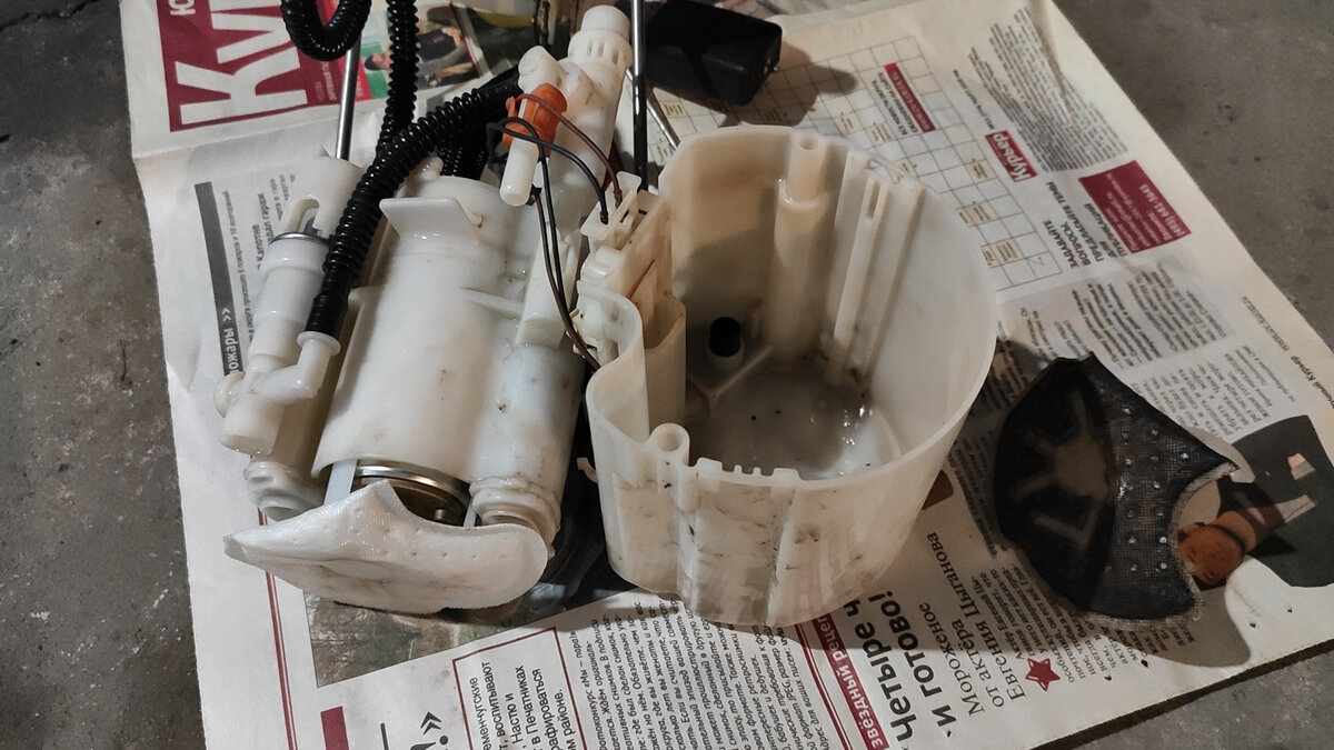 Сборка бензонасоса. Справа-налево: старая грязная сетка, стакан насоса, сам насос в пластиковом корпусе с уже надетой новой сеткой.