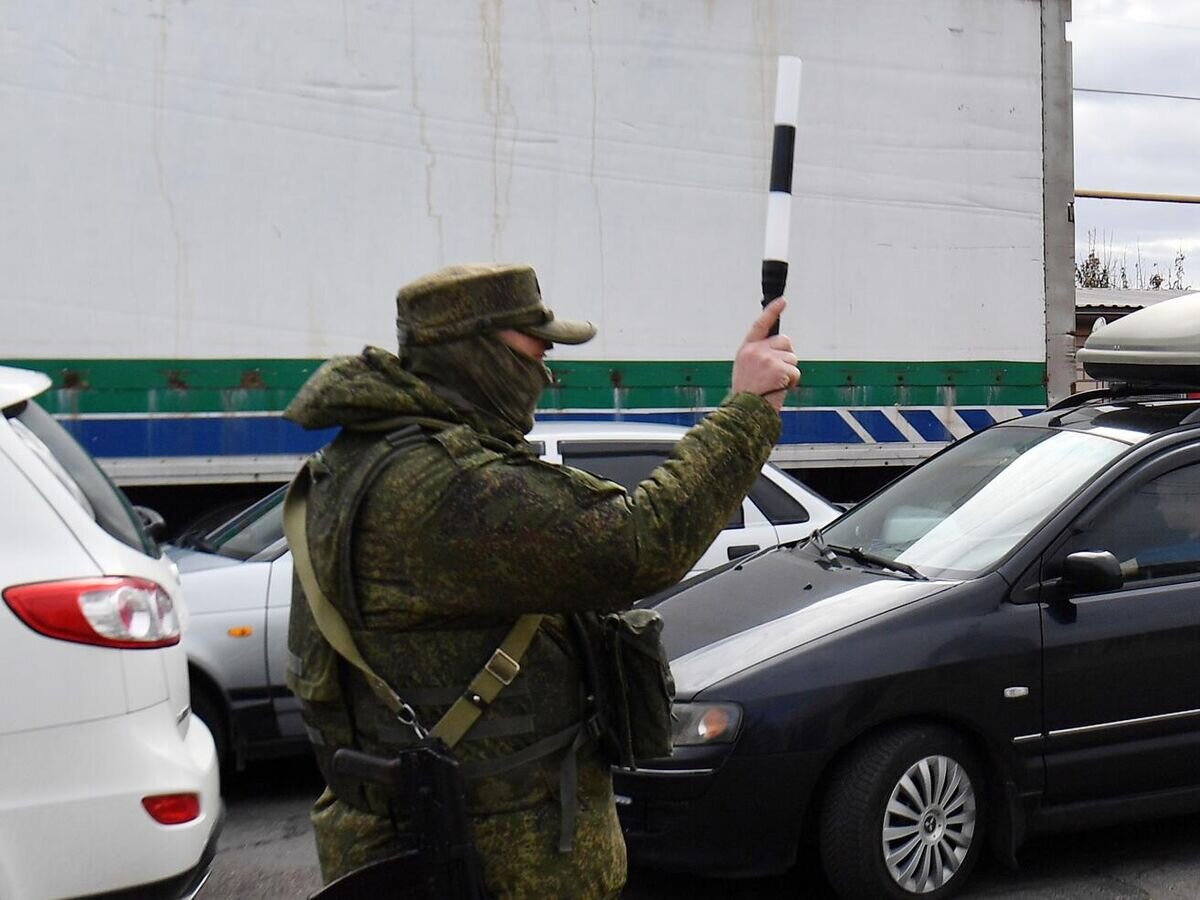 Сотрудник военной полиции регулирует движение в очереди на переправу во время эвакуации из Херсона© РИА Новости / Евгений Биятов