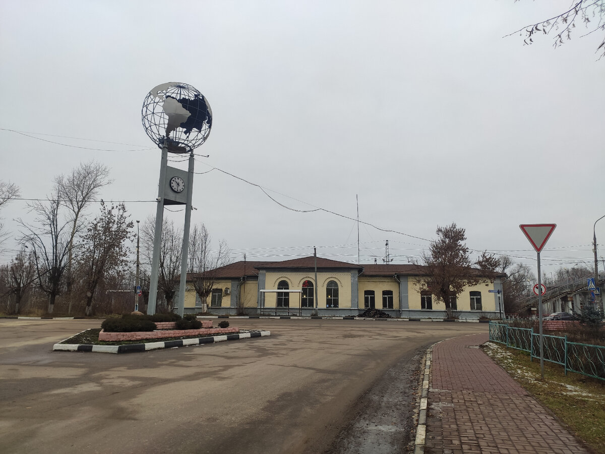 Стела с часами и макетом земли около железнодорожного вокзала