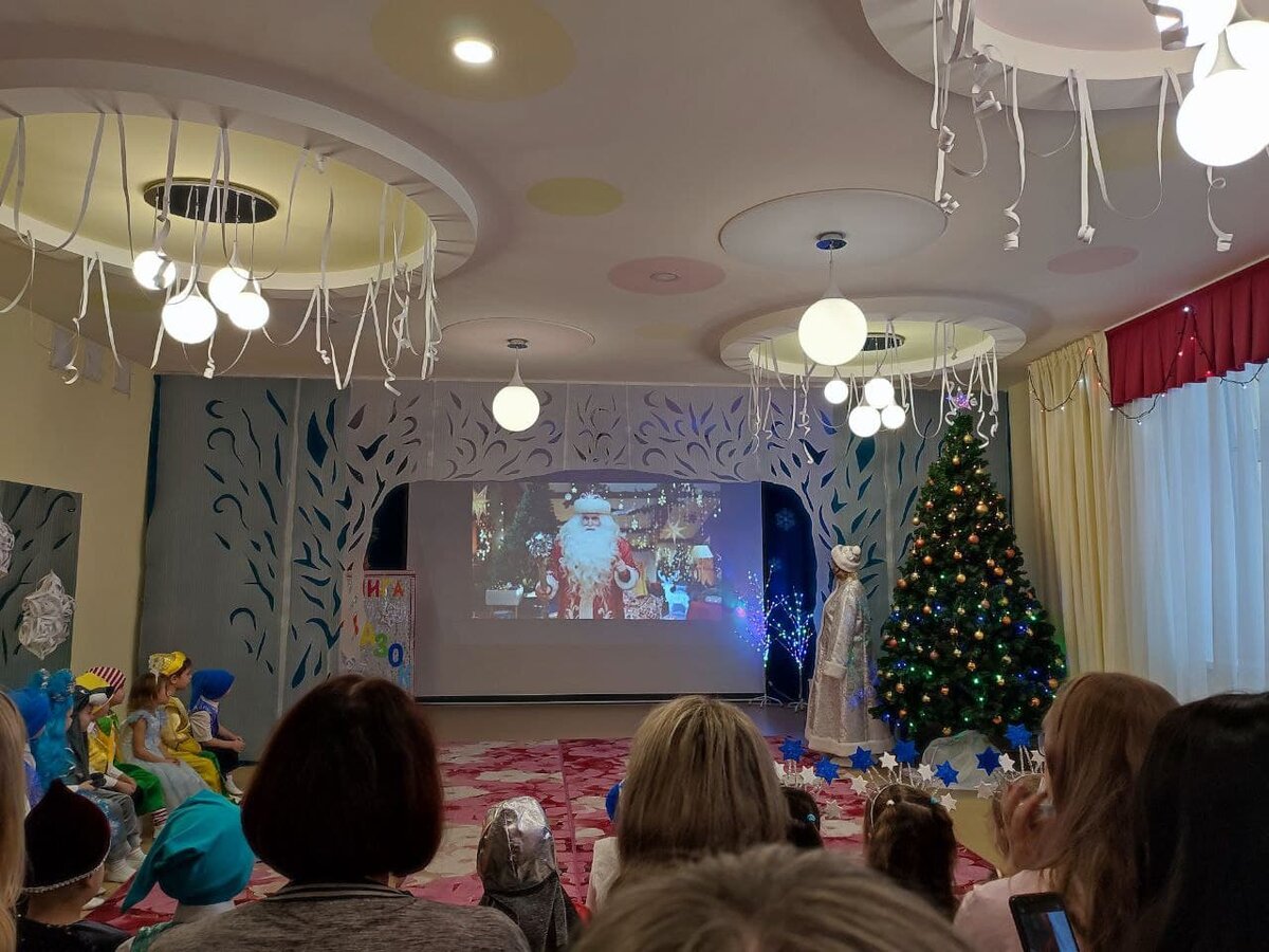 Дед Мороз из рекламы Мэйл.ру поздравляет присутствующих с Новым Годом. Справа у елки можно наблюдать одинокую и немолодую Снегурку.