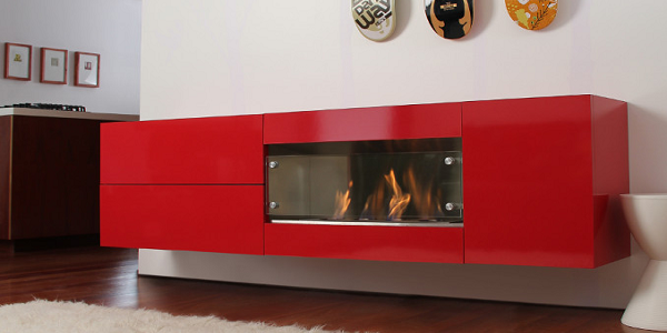 Чем больше блеска в яркой отделке, тем меньше размеры портала под биокамин. Компактную гостиную украсит подвесная глянцевая тумба на матовой стене. От телевизора над очагом стоит оказаться, чтобы броский цвет не спорил с видеорядом.