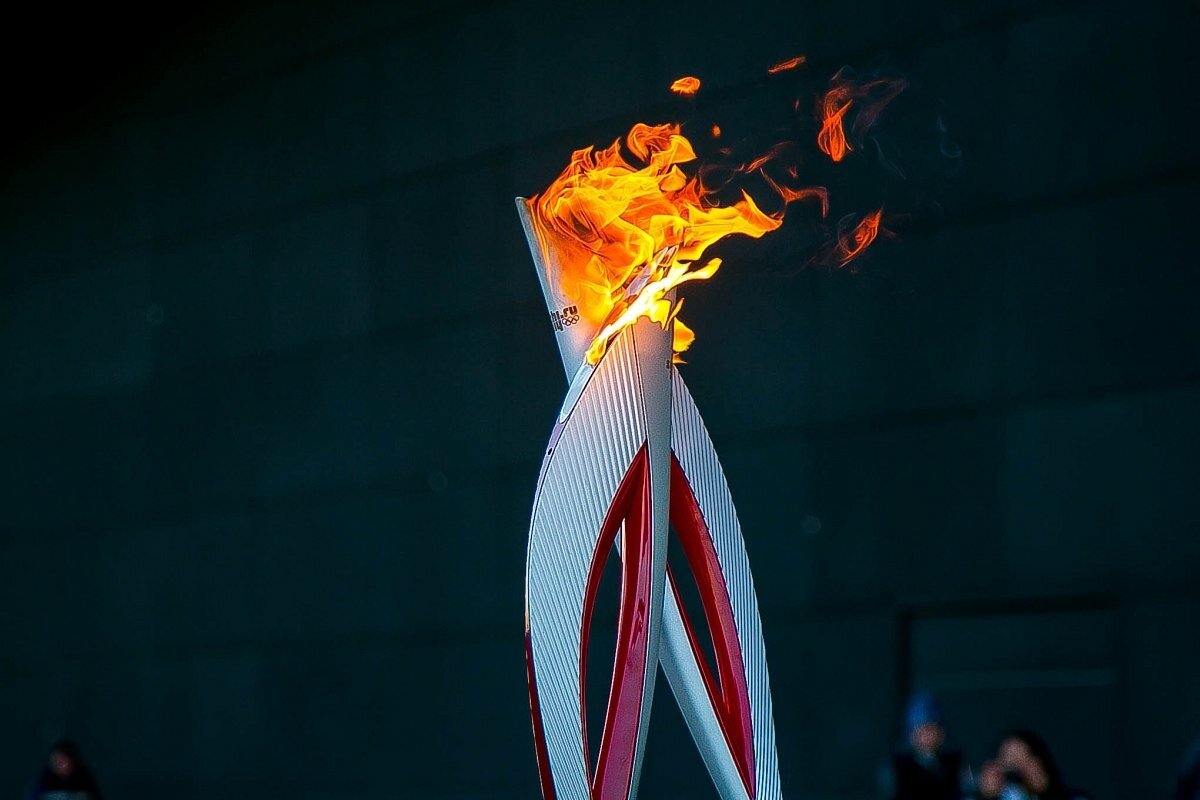Факел начал игру. Факел олимпийского огня Сочи 2014. Олимпийские игры огонь факел. Зажжение олимпийского огня в Сочи. Факел олимпийского огня Олимпийских игр.