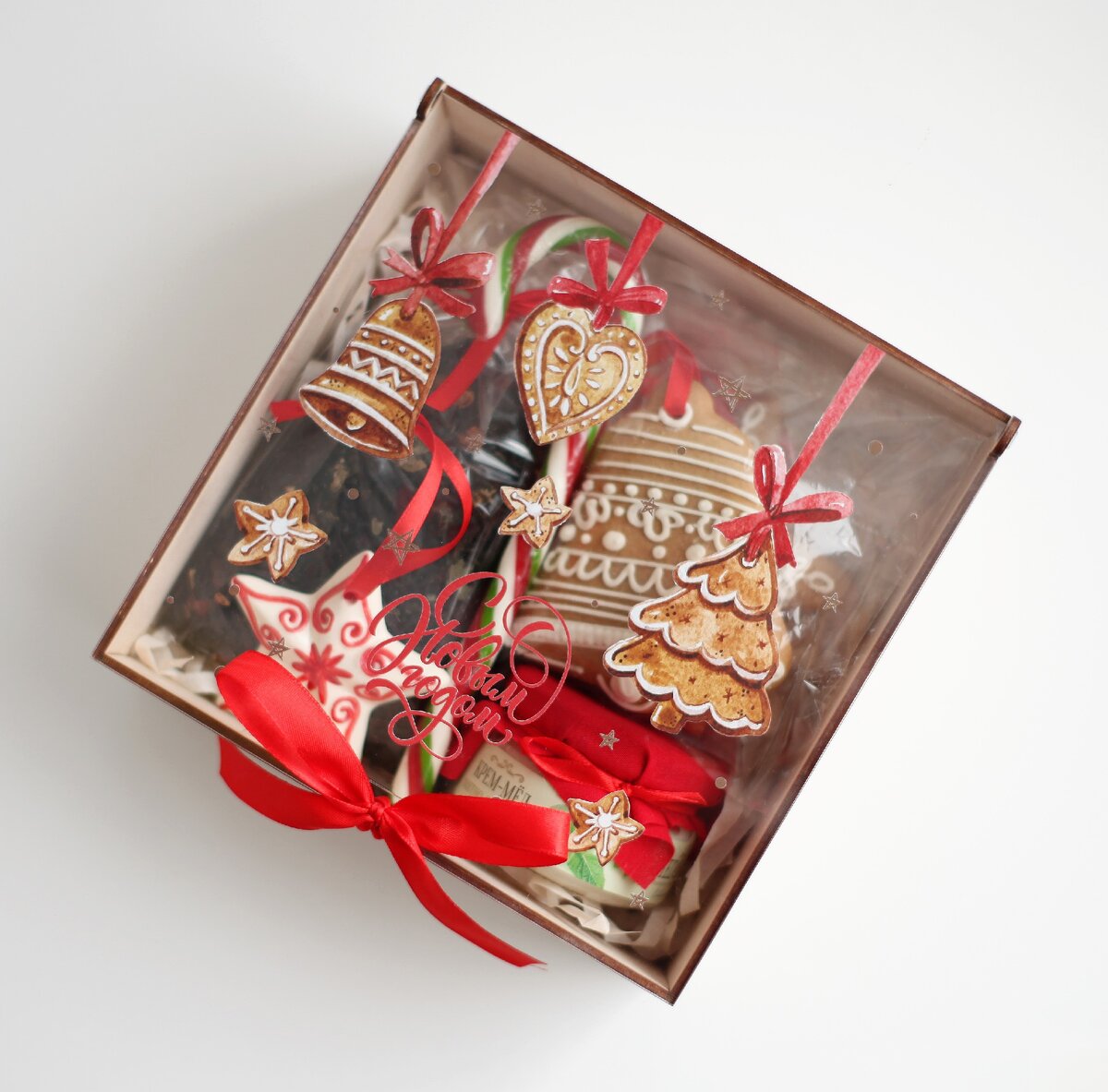  hellogifts.ru | - Имбирные пряники - Керамическая елочная игрушка - Крем-мед мятно-липовый 100 мл (возможны другие вкусы)- Карамельная «Трость» - Чай «Лесная ягода» 80 гр.смесь черного цейлонского чая, цедры шиповника, рубленного листа смородины и малины, с добавлением ягод аронии, смородины, облепихи, малины и кусочков клубники.- Пенал из дерева с прозрачной крышкой из оргстекла с полноцветной печатью (брендирование на крышке). 