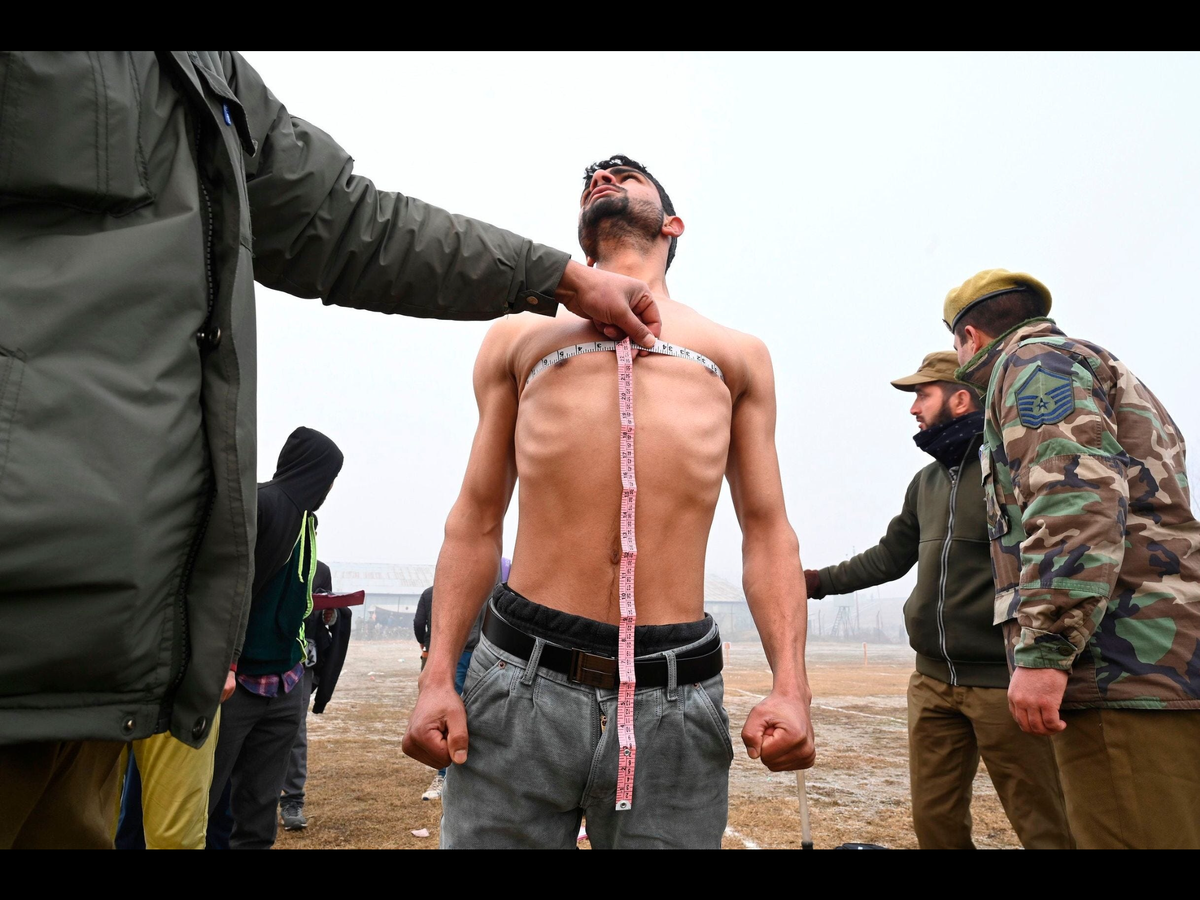 Сотрудники полиции замеряют размеры тела во время призывной комиссии в Шринагаре, Индия. Фотограф Tauseef Mustafa.