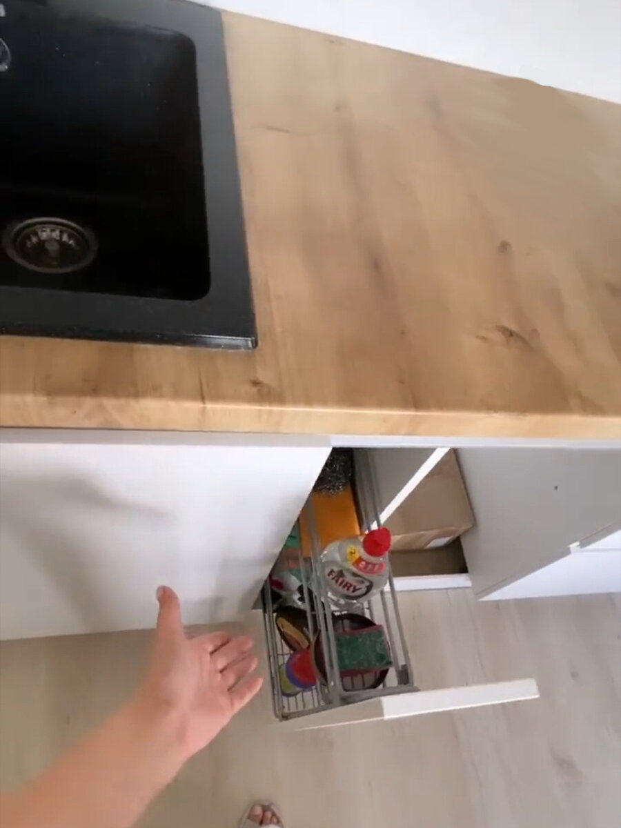 Полка по принципу бутылочницы. Там хранятся тряпки и моющие средства