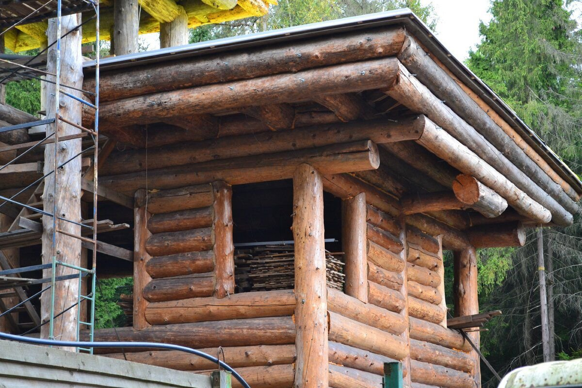 Штыри видны на верхних бревнах под крышей, если присмотреться