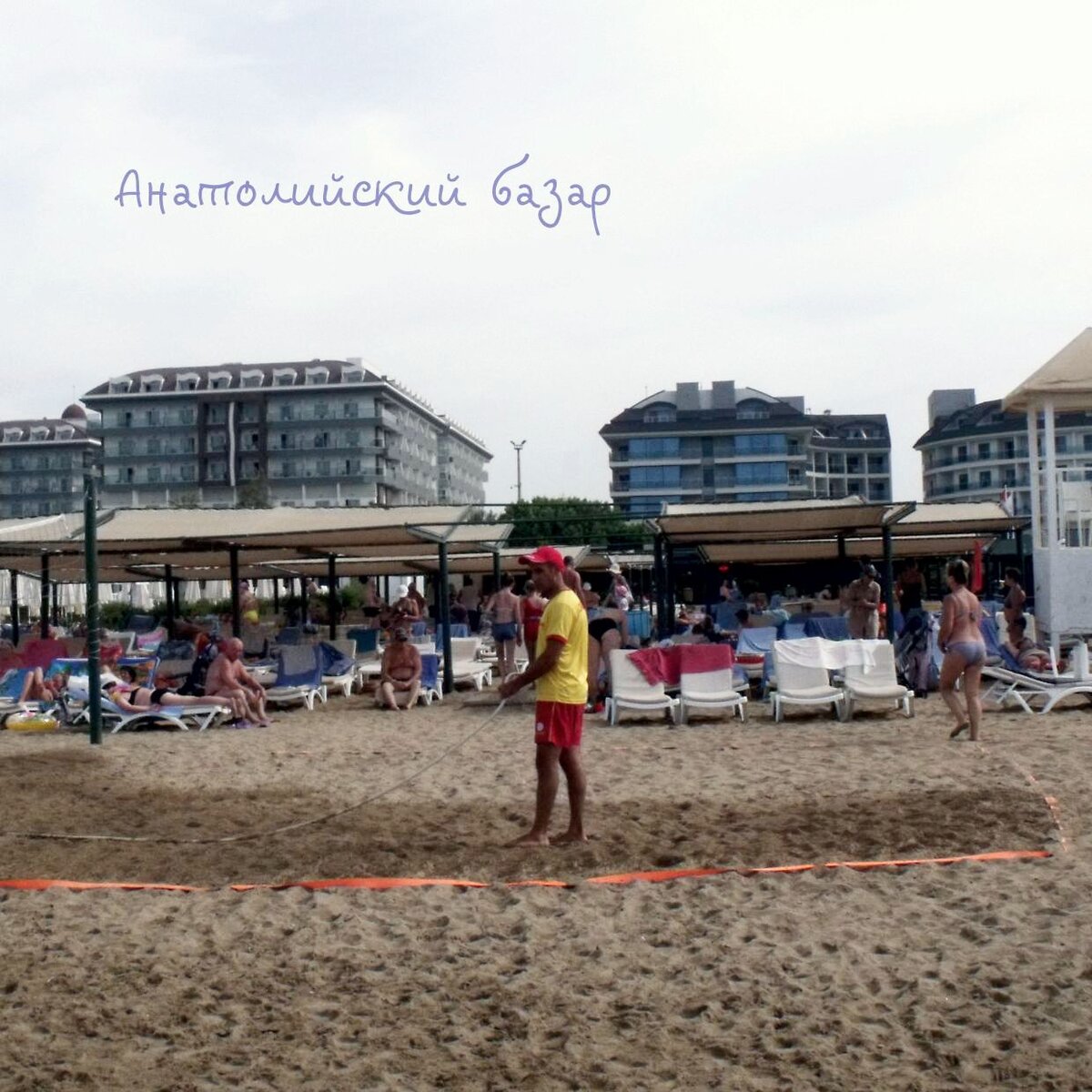 Аниматор готовит площадку для игры в волейбол.