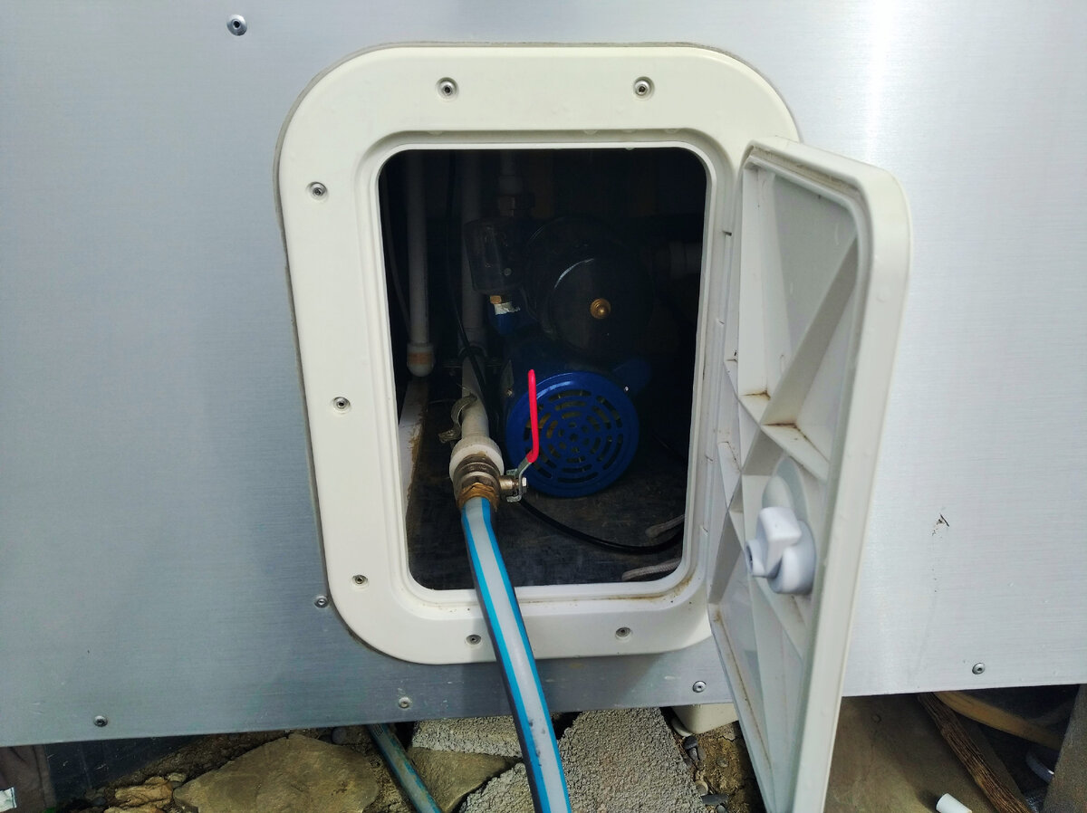 Лючок для доступа к насосу. Подсоединен шланг подачи воды.