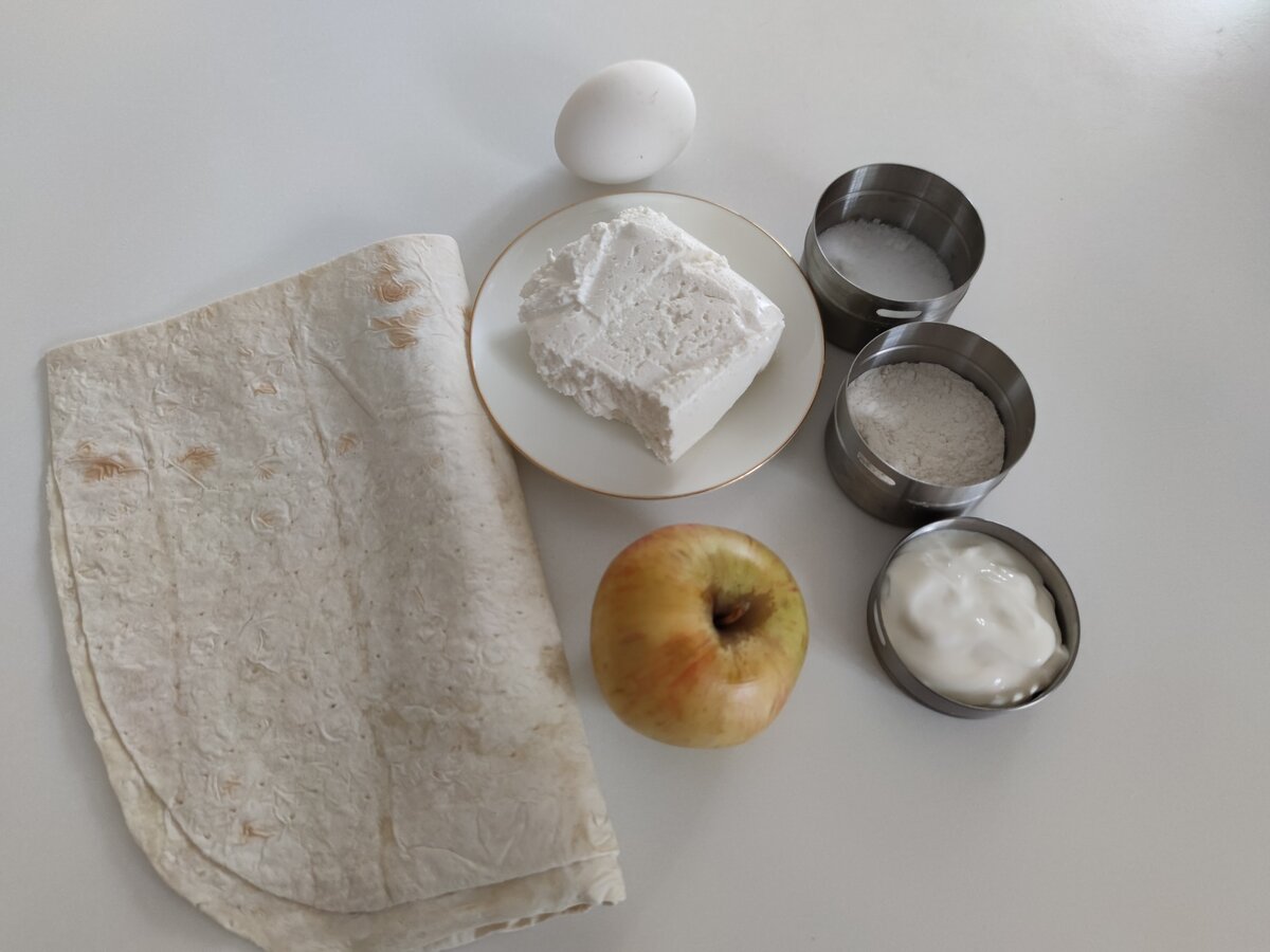 Ингредиенты: лаваш 150 гр, яблоко 150 гр , творог 100 гр, сметана 30 гр, яйцо 1 шт, сахар 20 гр, мука 20 гр